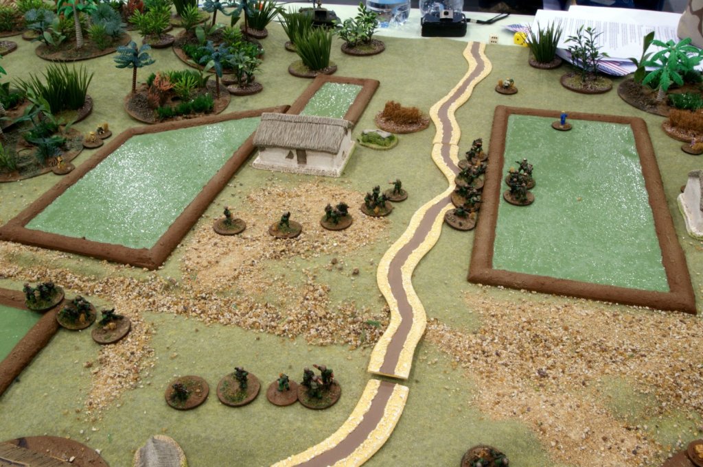   US troops are beaten back from the eastern end of the village, hunkering down by a paddy field's berm.  