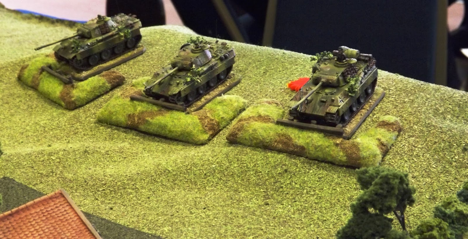 Panthers dug in above the farm open fire and take return fire from the lumbering British tanks