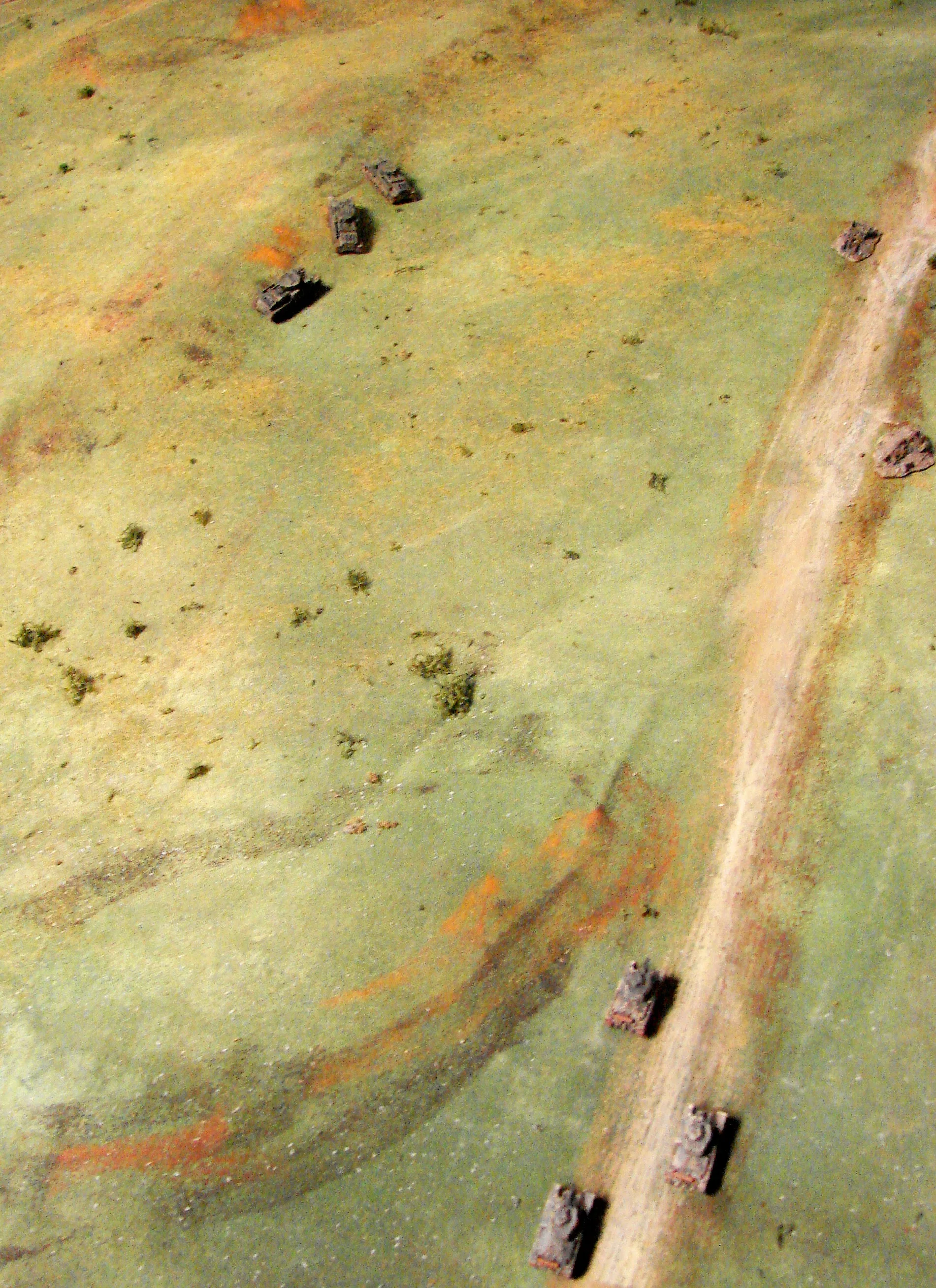 There are those T28s I placed a group of three broken down/abandoned T28 off to the side behind some rolling terrain. The German player had to spot them and of course he didn't know they were out-of-action. The terrain on this table was fairly rolling open grassland that sloped slightly down to the river. Some thick impassable woods were on the eastern half of the table. A few tree lines and a RR running across fom the NE to the SW made up most of the other features.