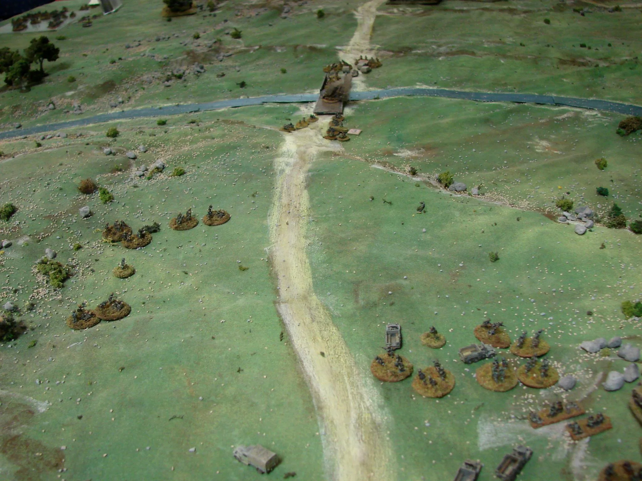 Advance on the bridge The Kiwi armoured cars have pulled back, slowly working their way around the burning 221 and avoiding the working RE unit. At this point the Germans are beginning to put a lot more fire on the RE then what they are receiving. One of the truck-mounted platoons moves up on the left. This is getting very stressful for the Commonwealth player as they have to keep the heads of the m/c troops that are close to the bridge down and not firing on the section working on the demo charges. Everything depends on the turn of the cards now.
