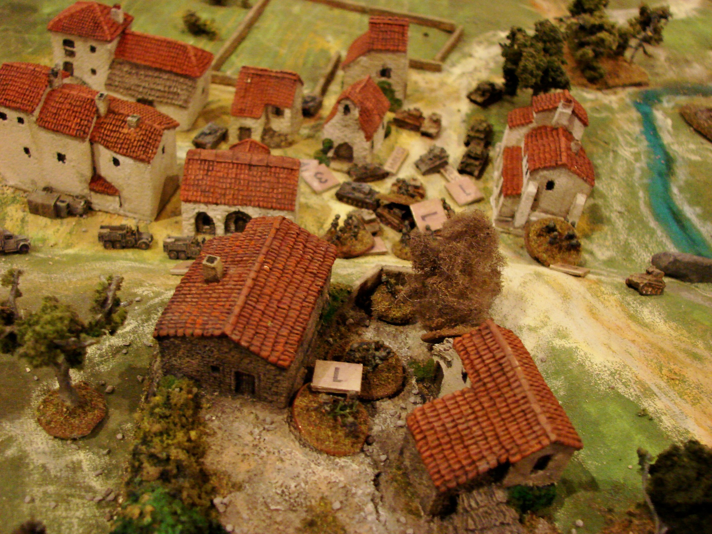The MKVIs prevail The MGs on the light tanks cut down enough German infantry to force them back up the hill to where their command element has arrived. And the CS tanks shift their fire up there. The light panzers also have suffered a lot of damage. Lots of shock among the armor in town. The British commander: The fight for the town has turned into a quagmire for the Germans. I was surprised that Chris didn't make a made dash for the edge of the board -- less than 18" from the center of the town. But after those first two Pzs got knocked out, they bottle necked the road. Pretty soon, the only way to go was around the town.