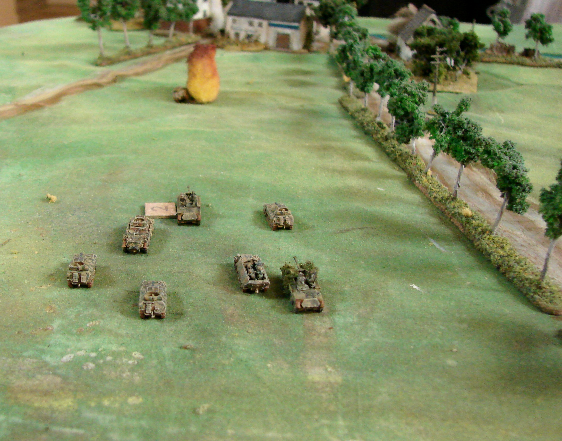 Enemy definitely spotted The 2 SS Pz Auf Abt assembles in the open. One of the Sdkfz 234/4 has aleady been disabled by the Valentines. One of the Sdkfz 250/9s sent forwrd has met a fiery end -the other one has gone through the tree line to the right. There are plenty of targets up ahead but even the 50 cals on the M3 scout cars can knock out any of these vehicles.