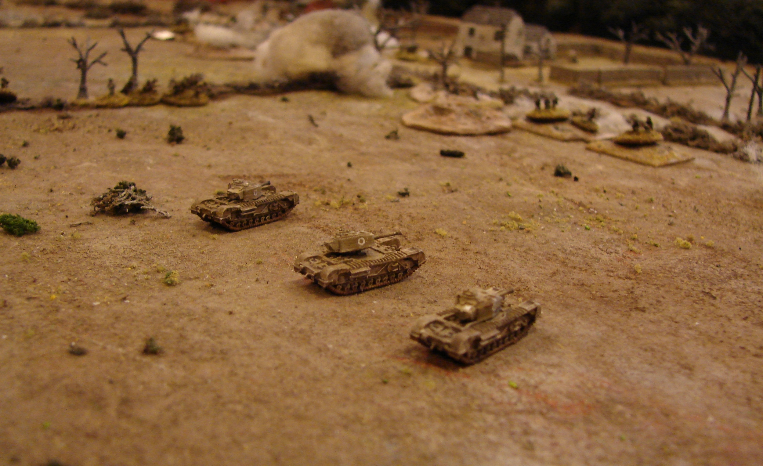 Another troop of Churchills It took them twice as long as anticipated to journey through the woods, but they are ready to eliminate any remaining German opposition. The Marders have not yet decided to get off the table (with no working guns, why stick around) and staying at maximum Panzerfaust range means that they heavy tanks are currently safe from harm (too bad I didn't notice the turret ajar before I took this pic). You can see the where the survivors of the 3rd platoon have fallen back to the ditch and hedge to the tanks' left.
