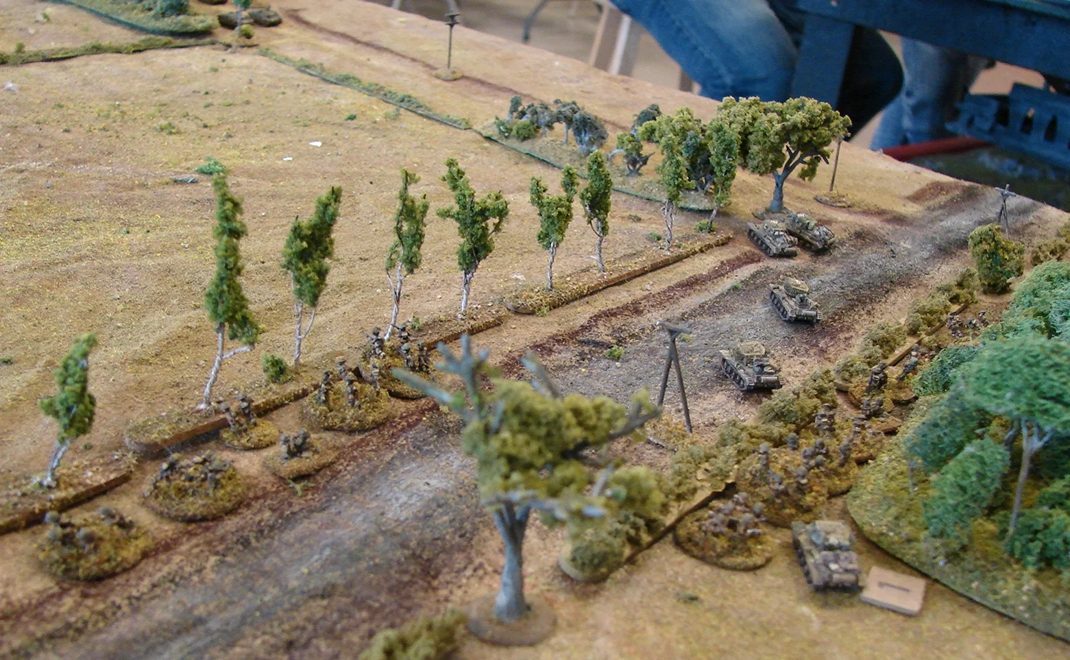 Deployed along the road The HQ troop with two CS tanks is on the road behind two regular Mk IVs now at the head of the column. The Squadron CO is in the trees off to the right. Cromwell with bad gun is behind the infantry along the hedge. The other platoon is in a ditch (dark brown line). You can see two Stugs at the top of the pic.