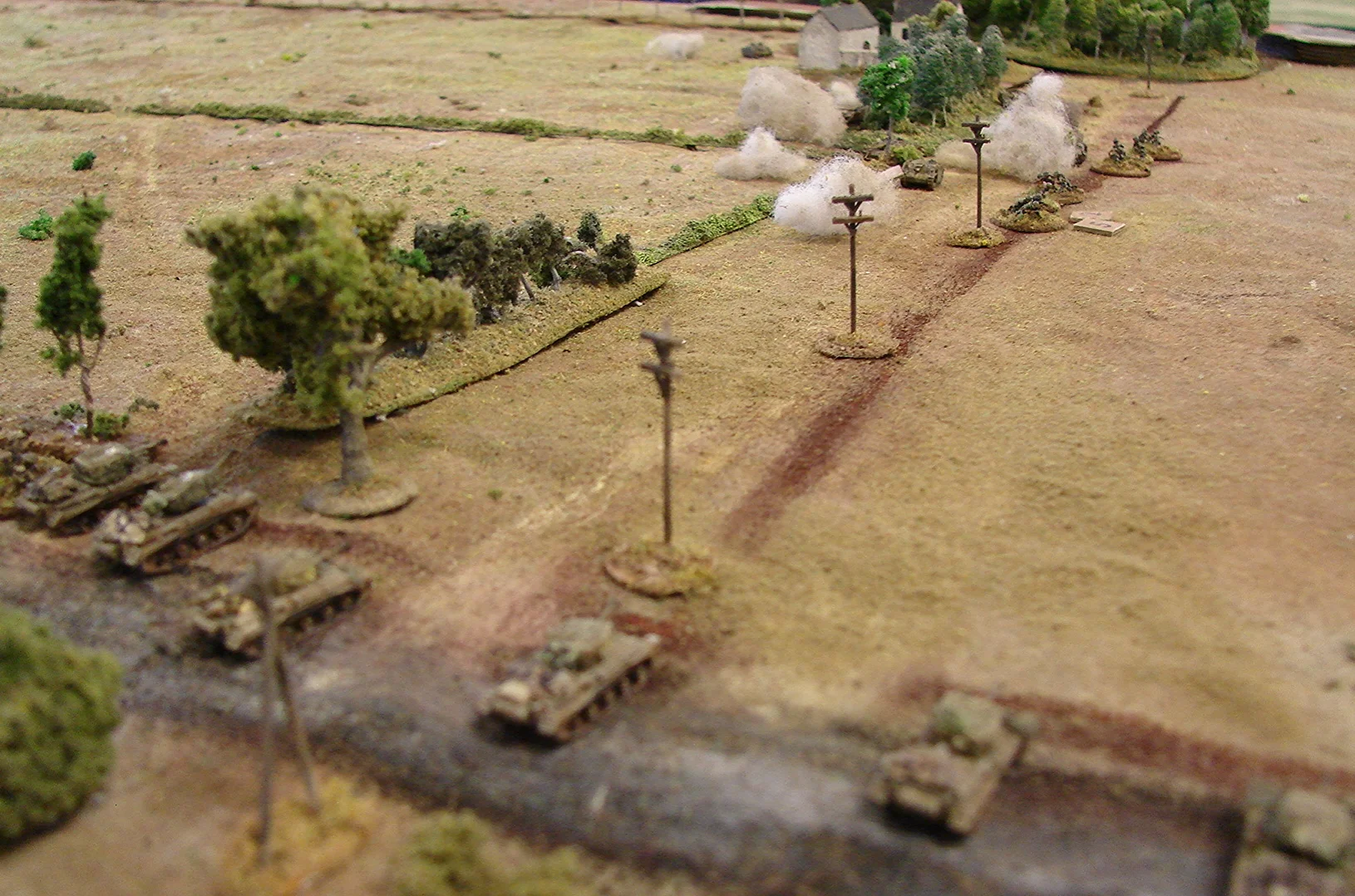 This is where both advances end The Welsh are not getting into Helchteren and the German counterattack on the Beringen bridgehead is well and truly stymied. The lead grenadier section is getting hosed in the ditch by as many Welsh riflemen as possible. The Stugs risk getting hit as soon as they come through the smoke. One Stug has temporarily gotten bogged going through the trees