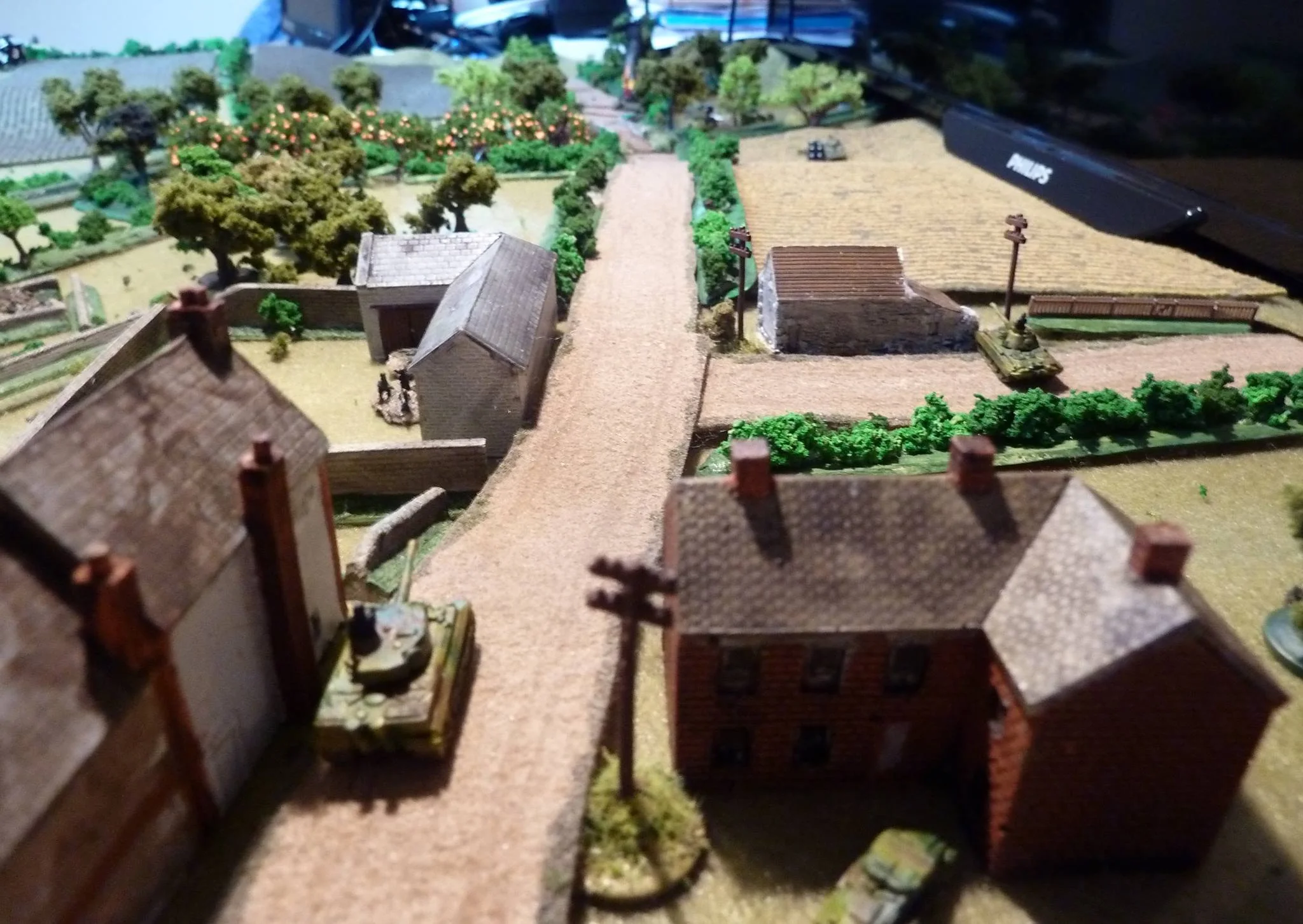 The view from Lambert down the top road. The Panther has moved forward to cover the fields. The Tiger covers the road with the burning M4 visible. Another Sherman in the field has been hit repeatedly and the crew bailed.