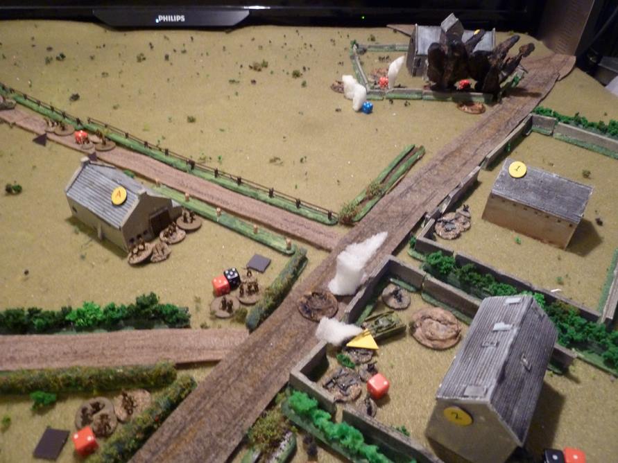  The Germans in the churchyard get some 3” mortar attention, while the Vickers in a universal carrier just visible on the fenced track adds to their misery, firing at ‘short’ range, keeping them Pinned and slowly adding Shock despite the hard cover o