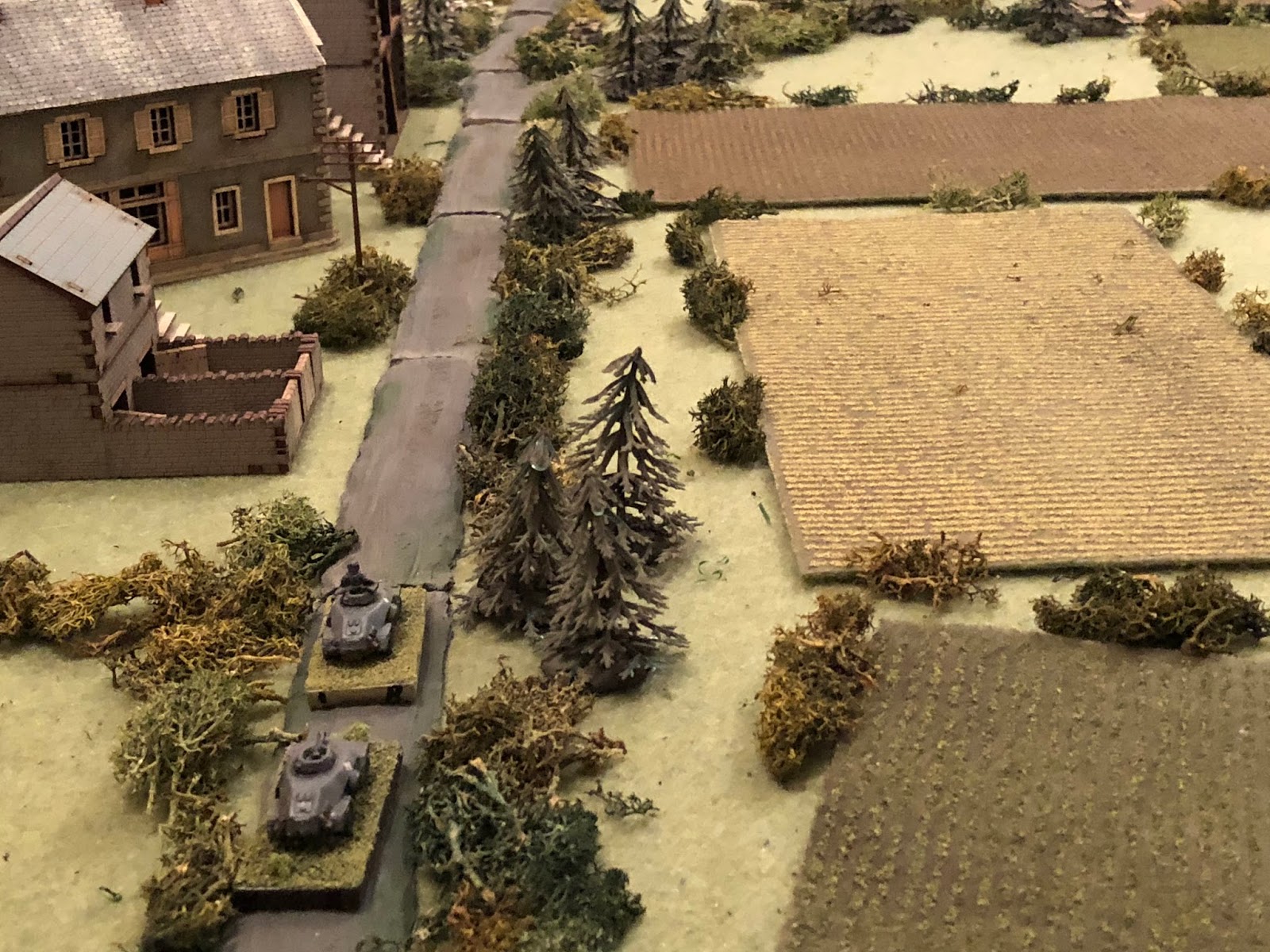  Hearing the reassuring roar of Panzer III engines coming up on his right (off camera to bottom right), Lt Weidner and Cpl Edst cautiously advance their armoured cars up main street, almost reaching the Granary (top left). &nbsp;Lt Weidner spots some