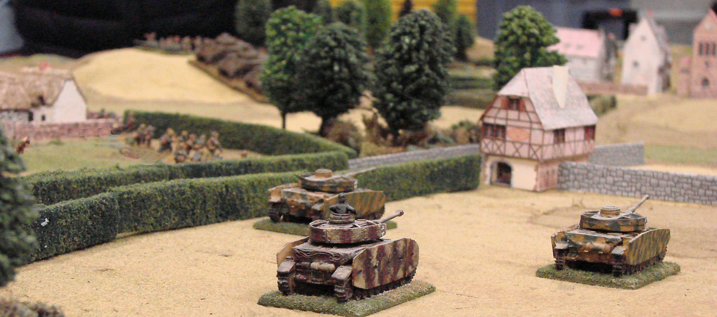 On the right, armor pounds the chateau with high explosives while the infantry drives into the adjacent woods.