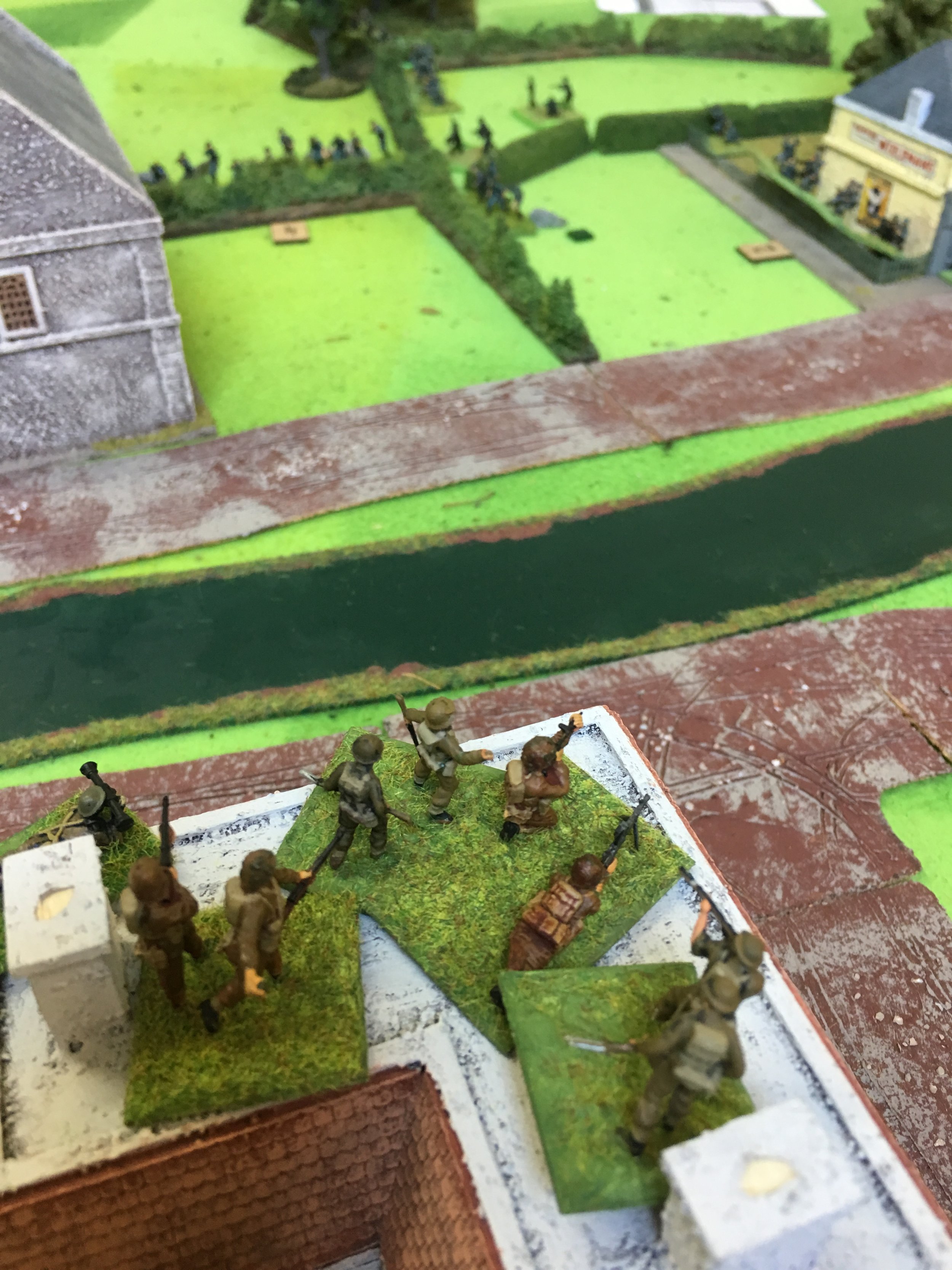 British defenders firing from the rooftops at the German attackers in the distance