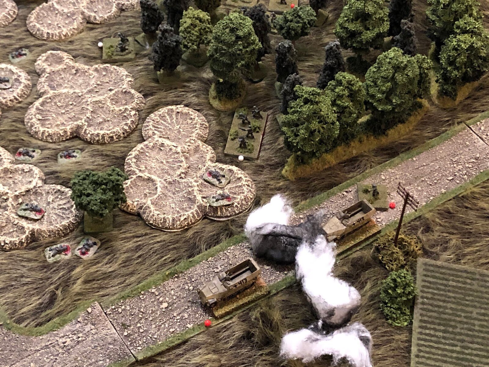  It's been nothing short of a catastrophe: the last remaining squad is 'men down' (white bead at center), the lead halftrack (bottom center) is suppressed, and the PC falls back behind the last halftrack, suppressed (right)! 