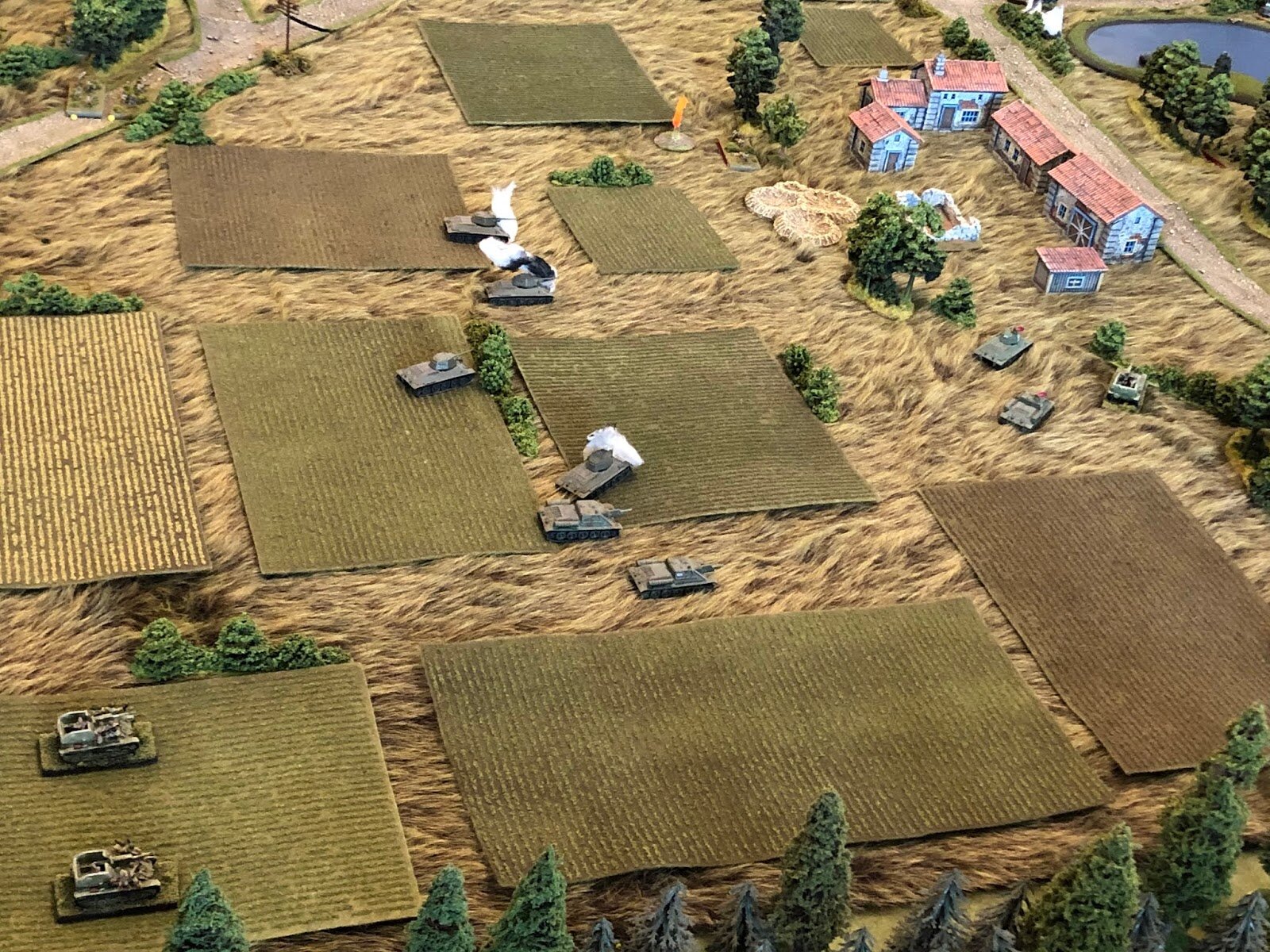  On the Soviet right, their SU-122 pushes forward. Feeling the heat from the German AT guns (off camera to top centre) and knowing they’re coming from the left , but not from exactly where, the trailing two SU-122s move up and take shelter behind a b