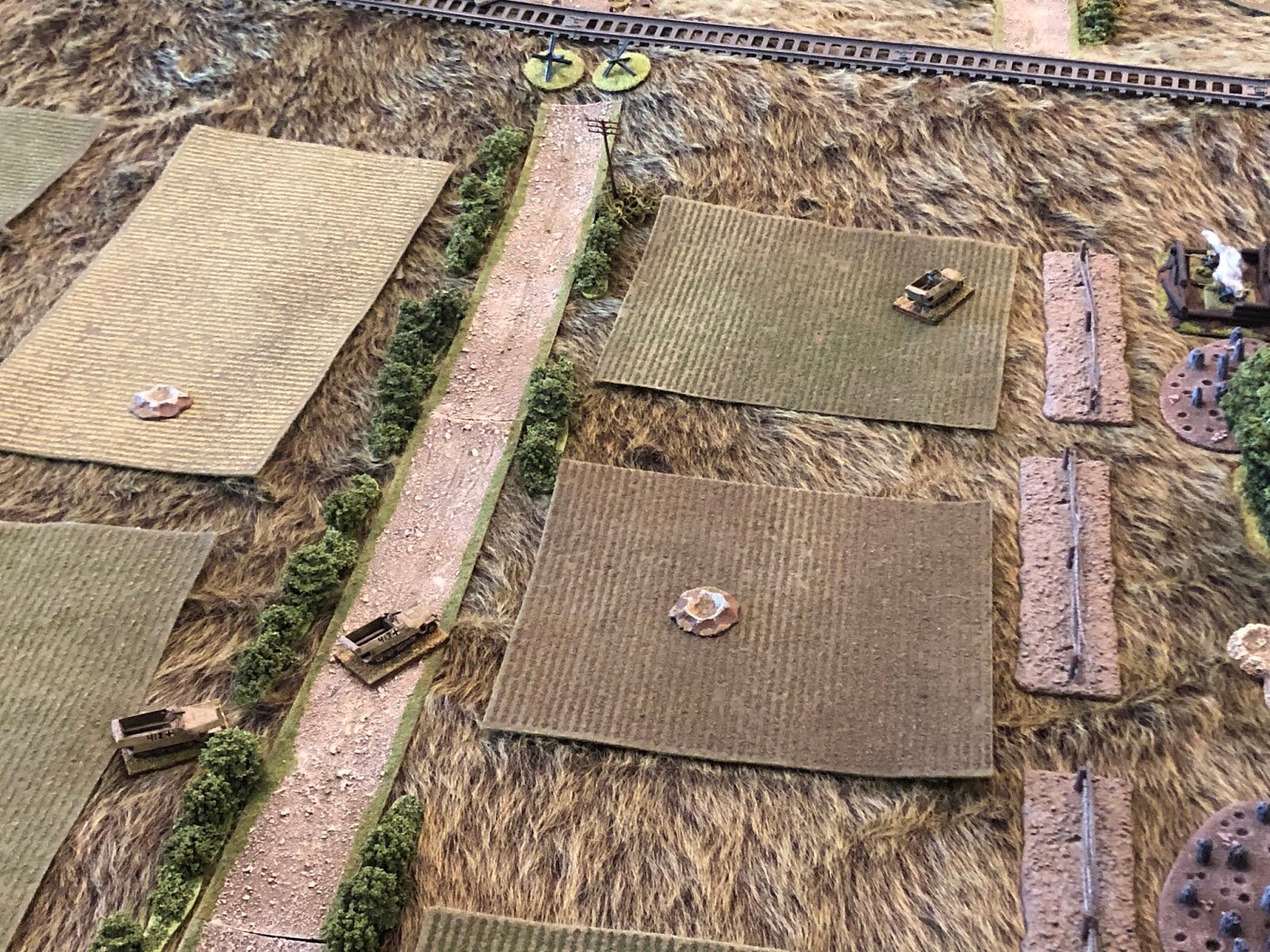  In the centre with the German halftracks, the Platoon Commander has spotted movement atop the railway embankment, so he orders the other two vehicles (bottom left) to halt while he pushes forward to scout it out (right top)… 