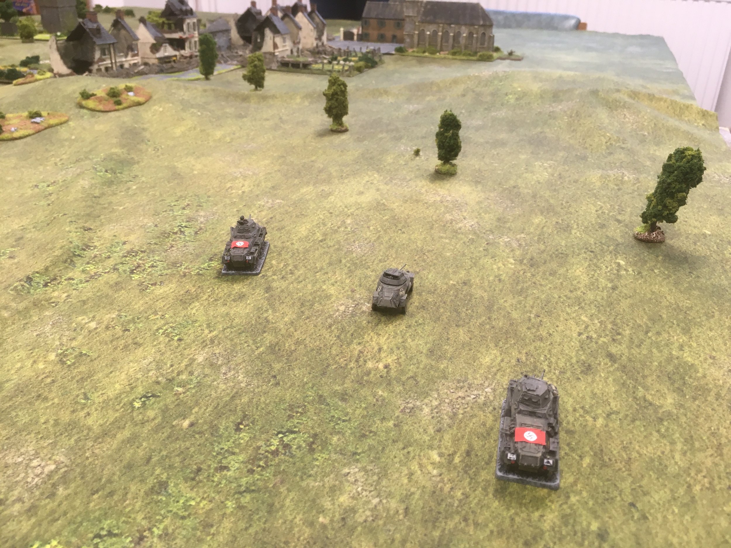 The German armoured car reconnaissance platoon moves across the French countryside towards the village...