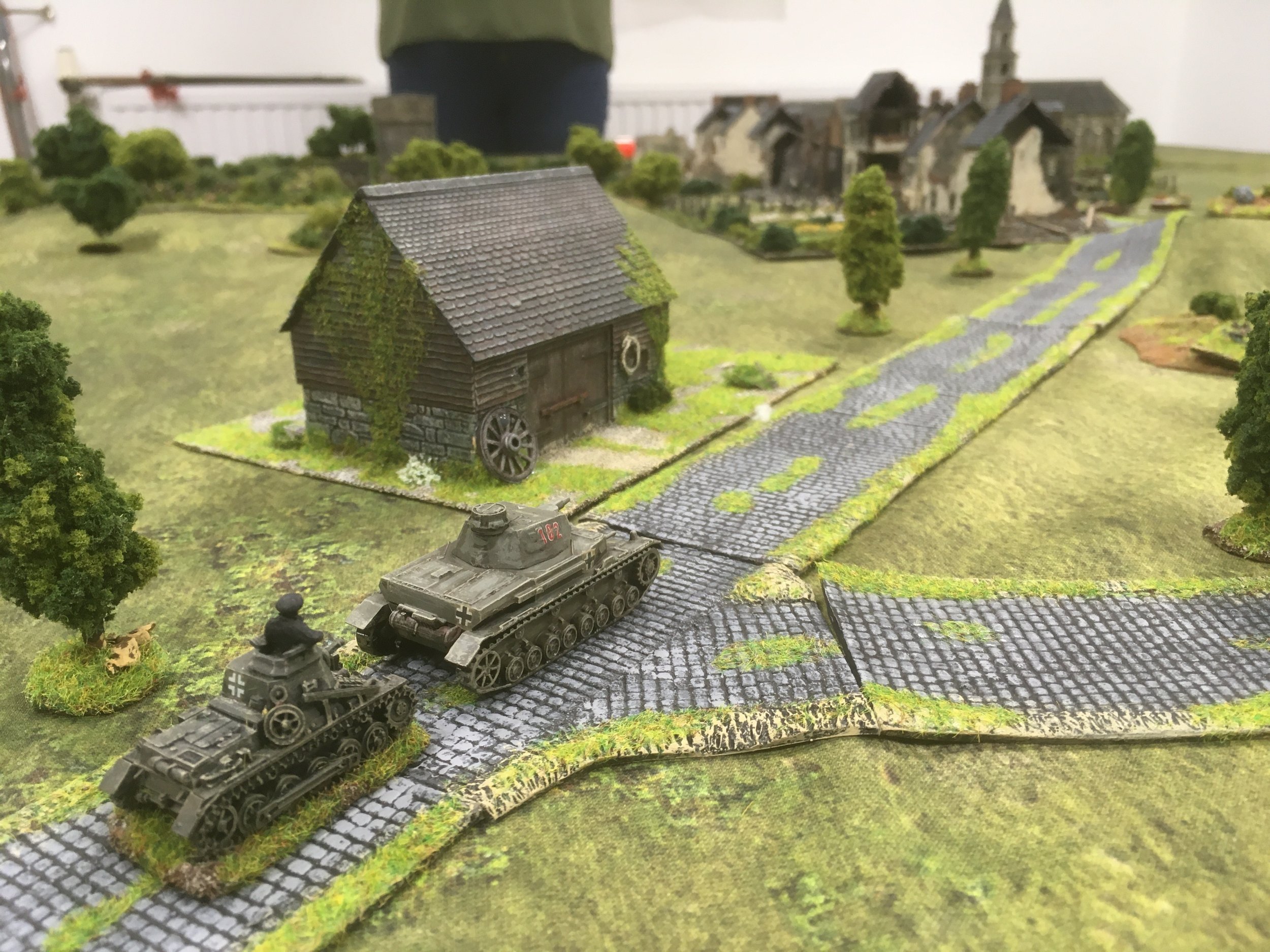 The Panzer IV moves swiftly down the road in an attempt to relieve the motorcycle troops.