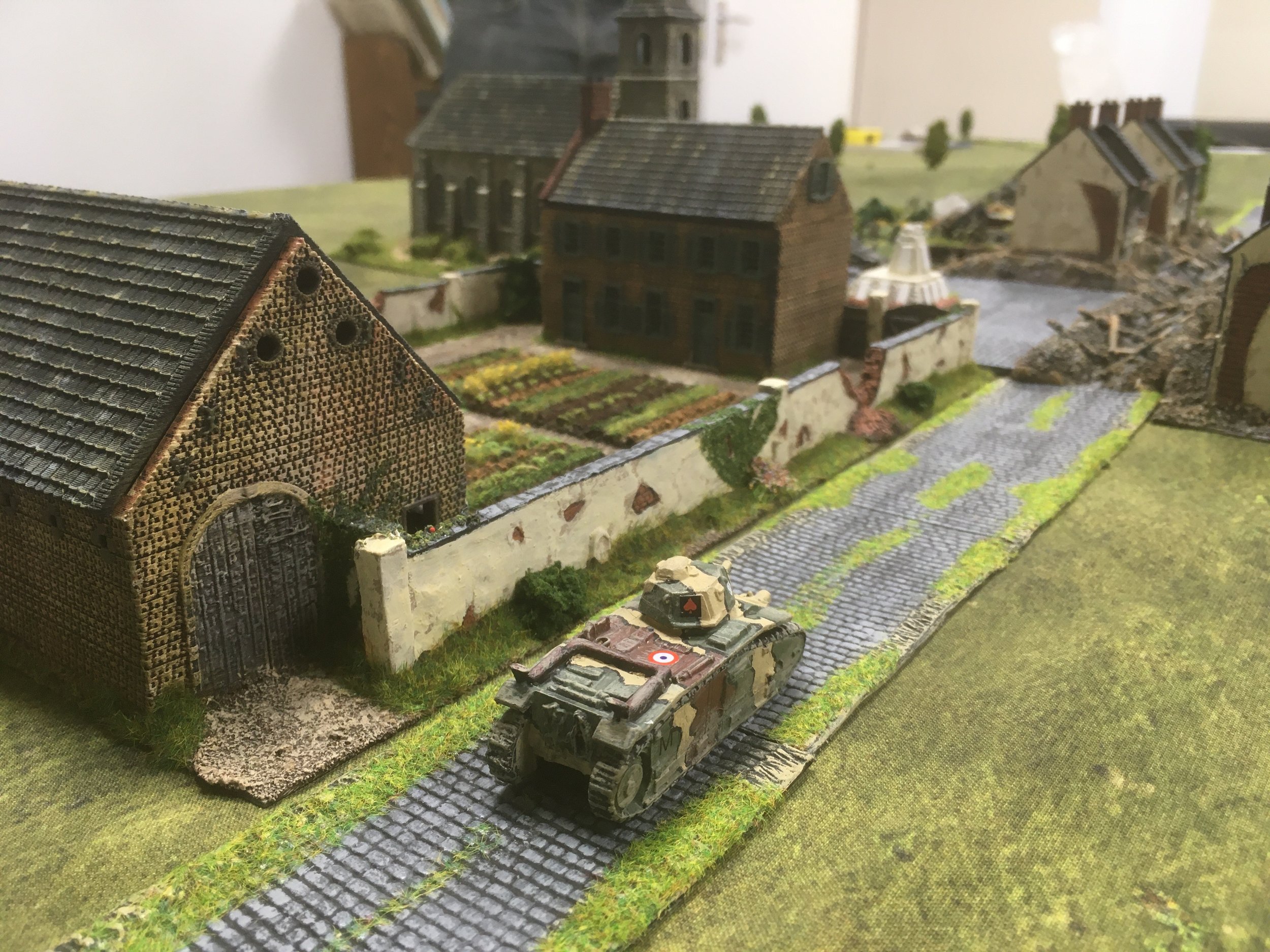 Rather late in the day, a French Char 1B trundles up the road towards the village.