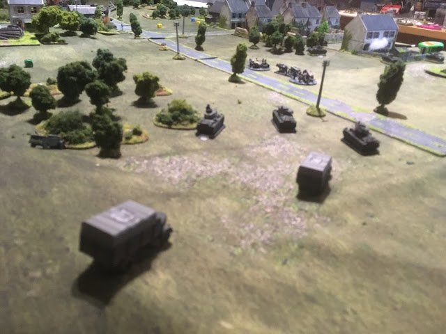 With the British armour rushing down the road, the Germans attempted to get their slow moving lorries across the road so to de-bus the infantry and attack the village...