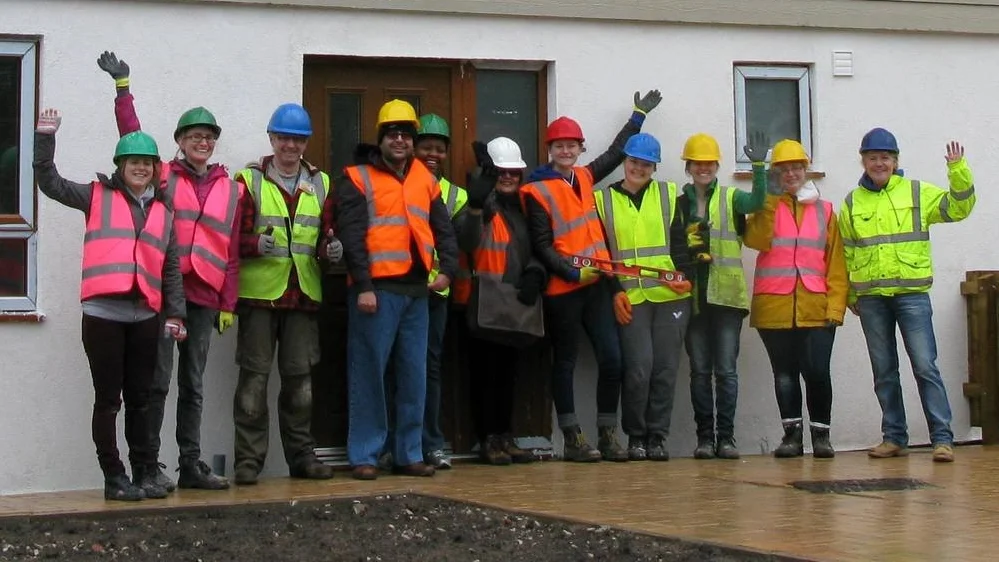 Some of HPBC’s staff, home owners and volunteers celebrate the latest award shortlistings in front of the most recently completed Kingsley Road homes.
