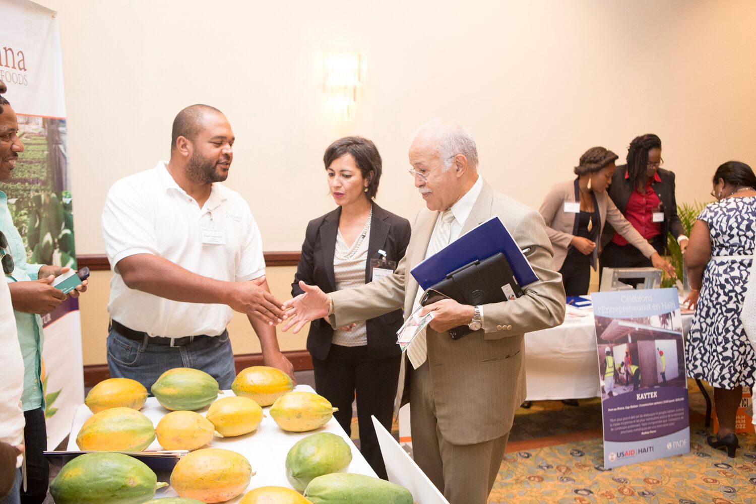 SIENNA Agricultural Holdings is a business that produces high-quality papaya. The booth gets a visit from Robert Labrousse, minister of Haitians Living Abroad.