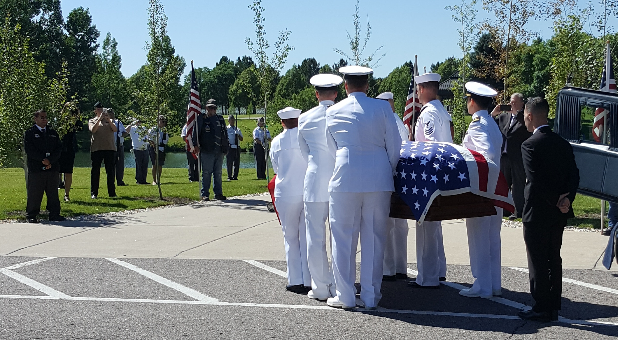 The flag-draped casket carrying the remains of sailor Wallace Eakes is carried by a Naval Honor Guard to a committal shelter at Fort Logan National Cemetery.