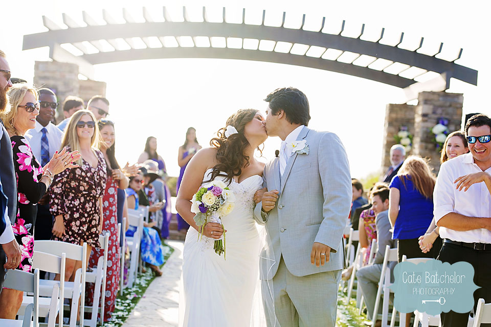 Sneaking in another kiss as husband and wife, as their guests cheer on!