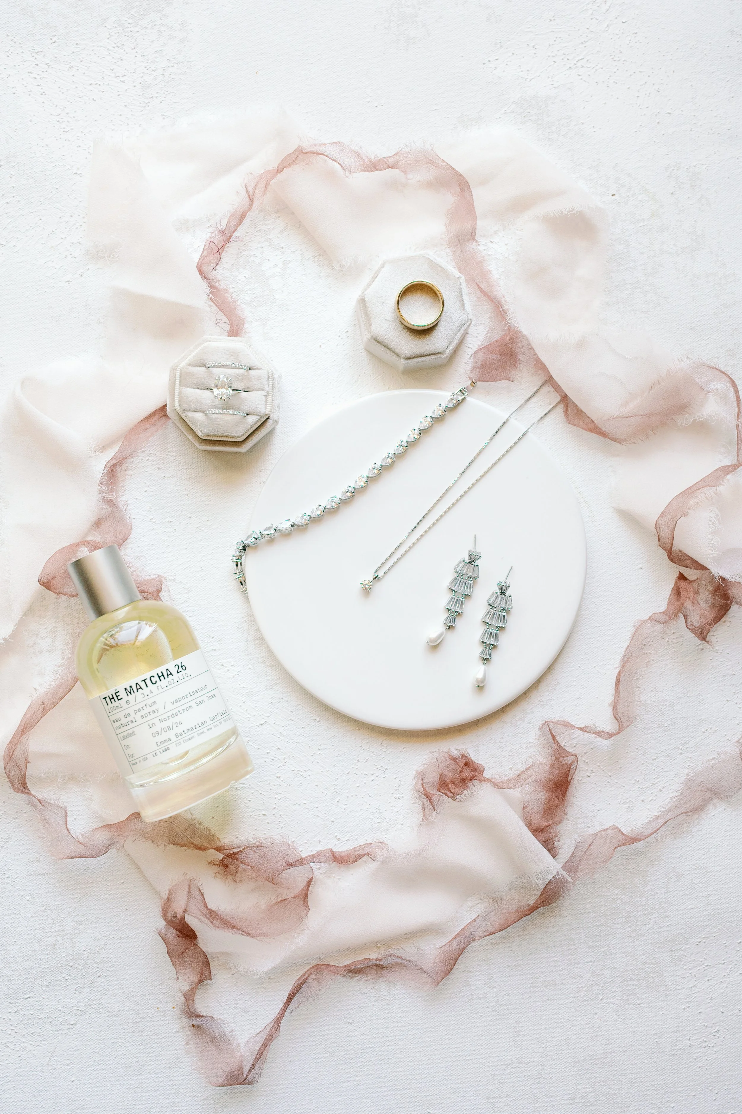 Bridal detail flat lay with jewelry, rings, and perfume at Tivoli Italian Villa in Escondido