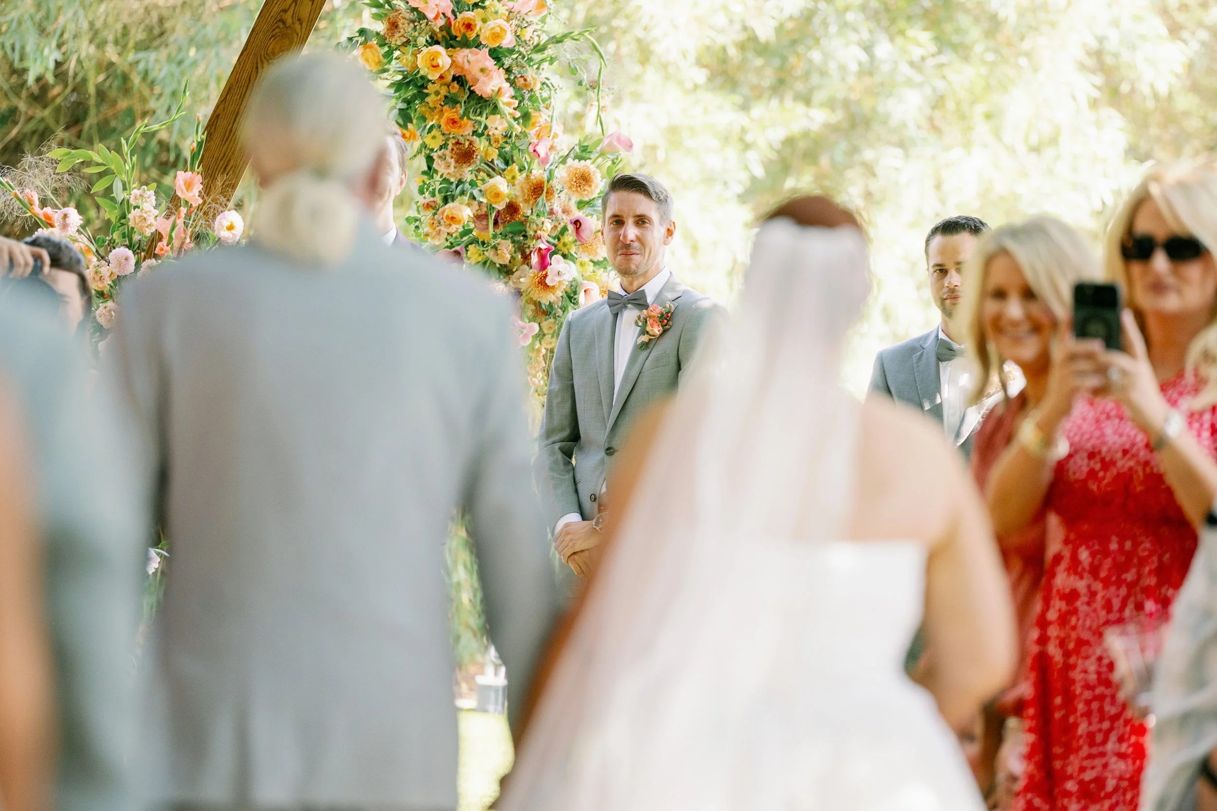 Outdoor wedding ceremony groom reaction to bride walking down the aisleat Ethereal Gardens in Escondido California