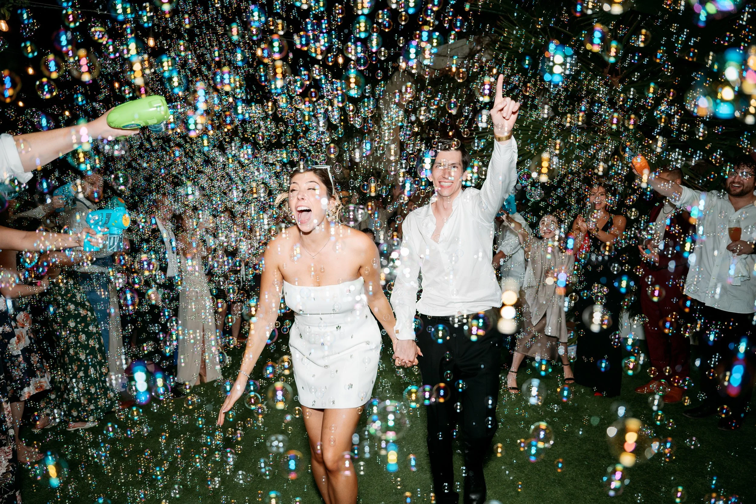 Bride and groom exiting through bubbles during grand exit at Tivoli Italian Villa wedding in Escondido, California