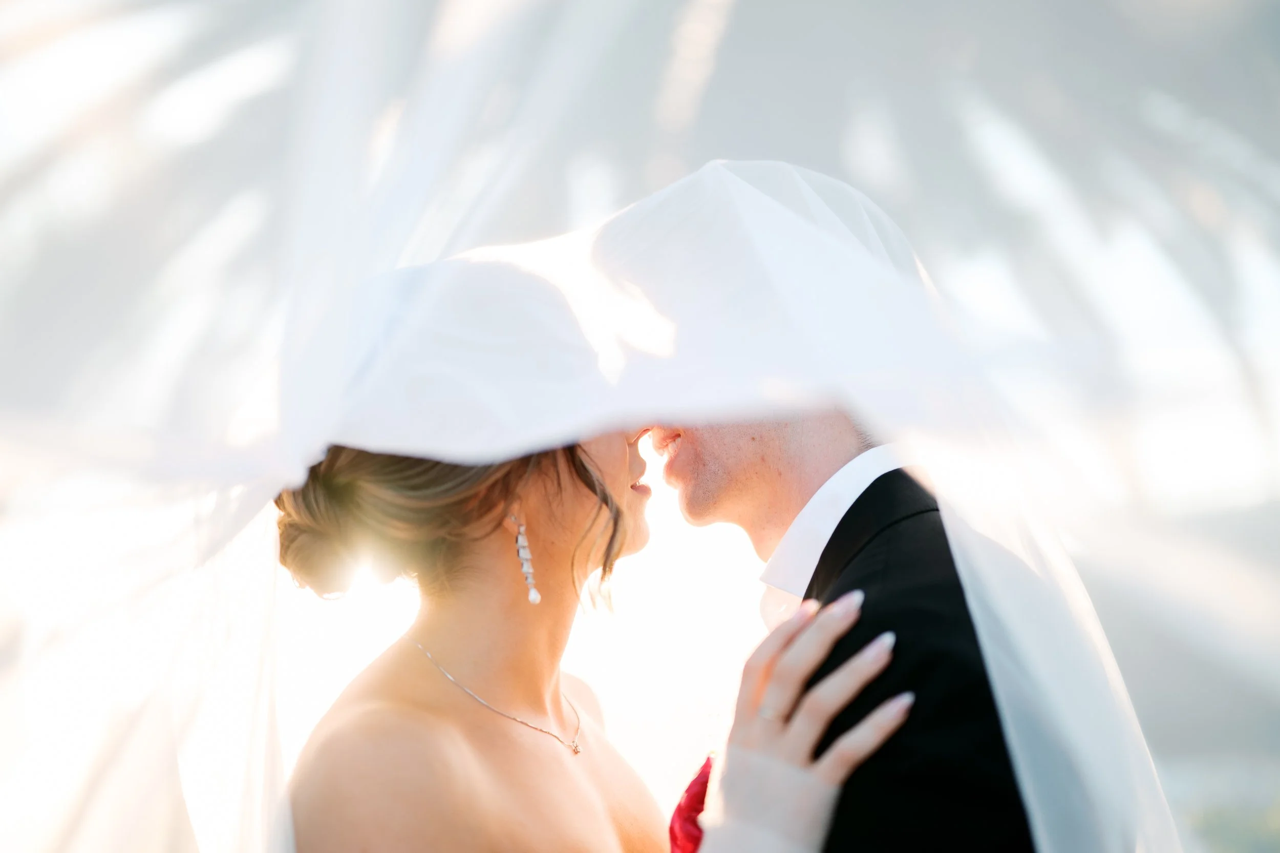 Bride and groom under veil during golden hour portraits at Tivoli Italian Villa in Escondido, California