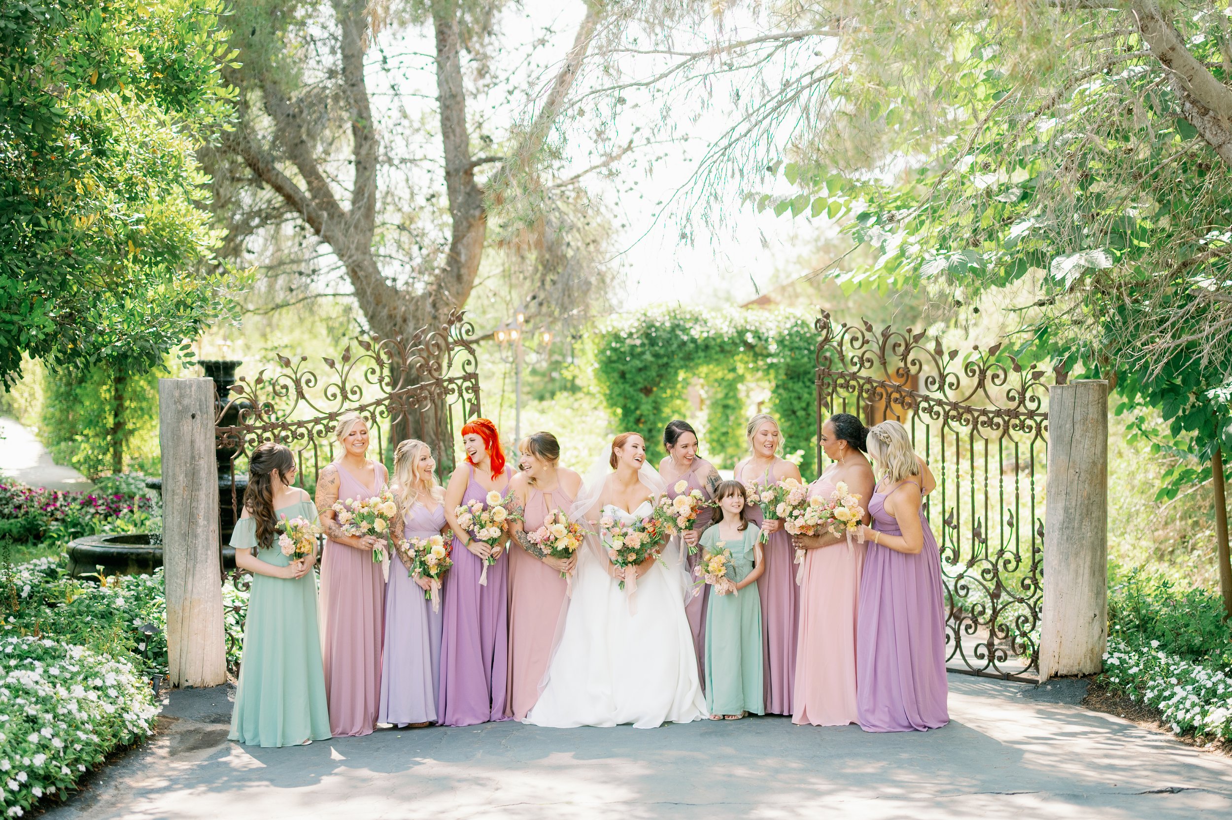 Bridesmaids in pastel color dresses at a Southern California garden wedding