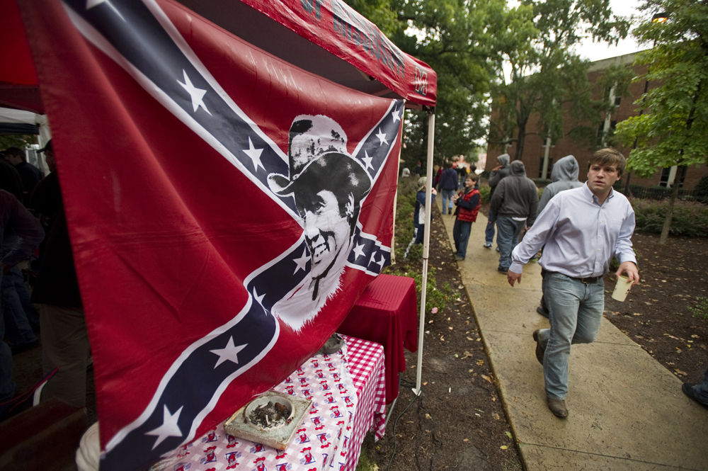 Ben Sigman looks at a Confederate flag featuring an image of Elvis Presley hung from a tailgating tent on the University of Mississippi campus before the Ole Miss Rebels take on Texas A&M University.