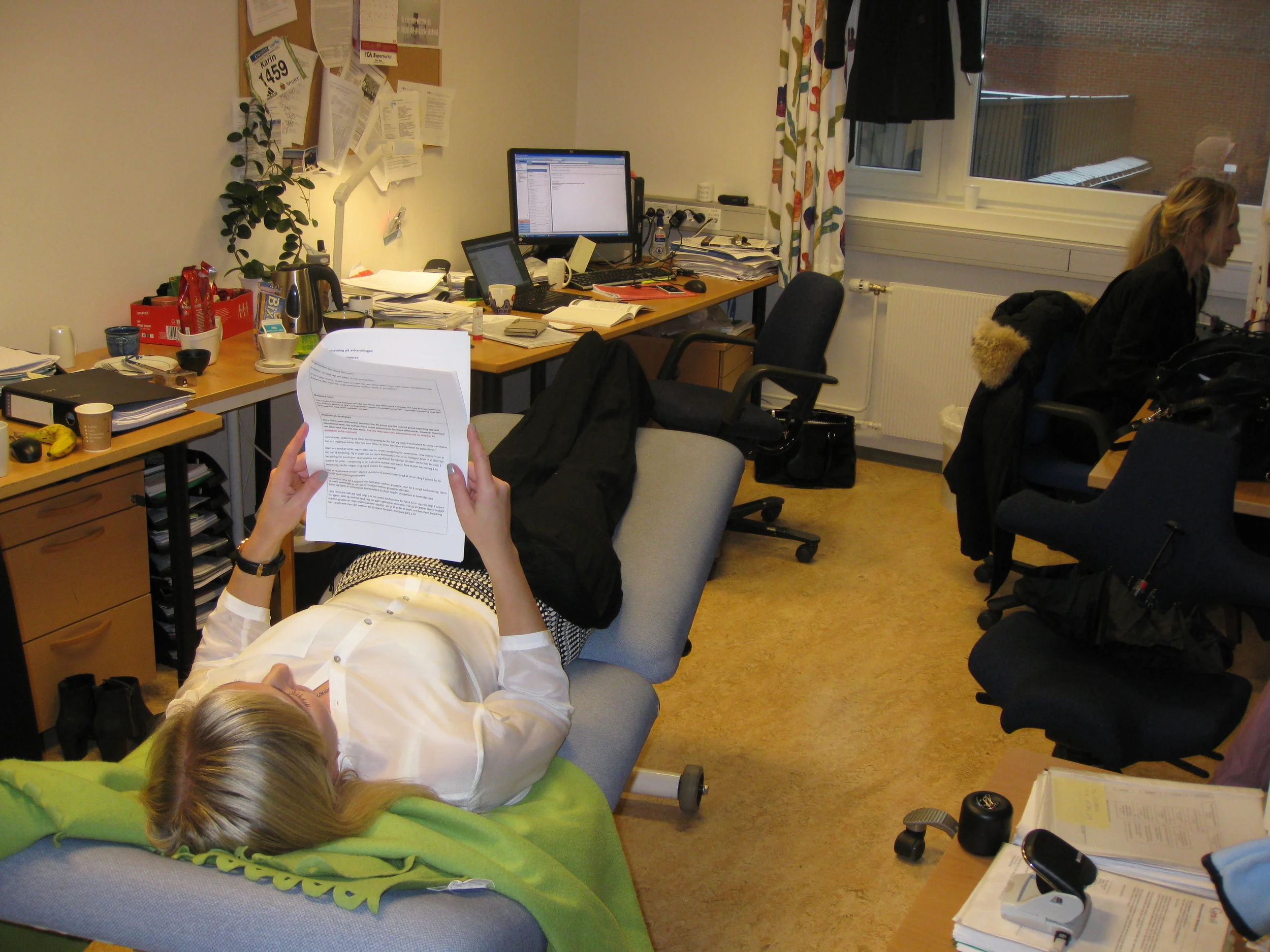 Etter prøveforelesning og før disputasen var stemningen på kontoret stille og konsentrert. Den blivende doktoren fant seg like godt en behandlingsbenk å slappe av på og prente inn det siste før hun skulle i ilden igjen.