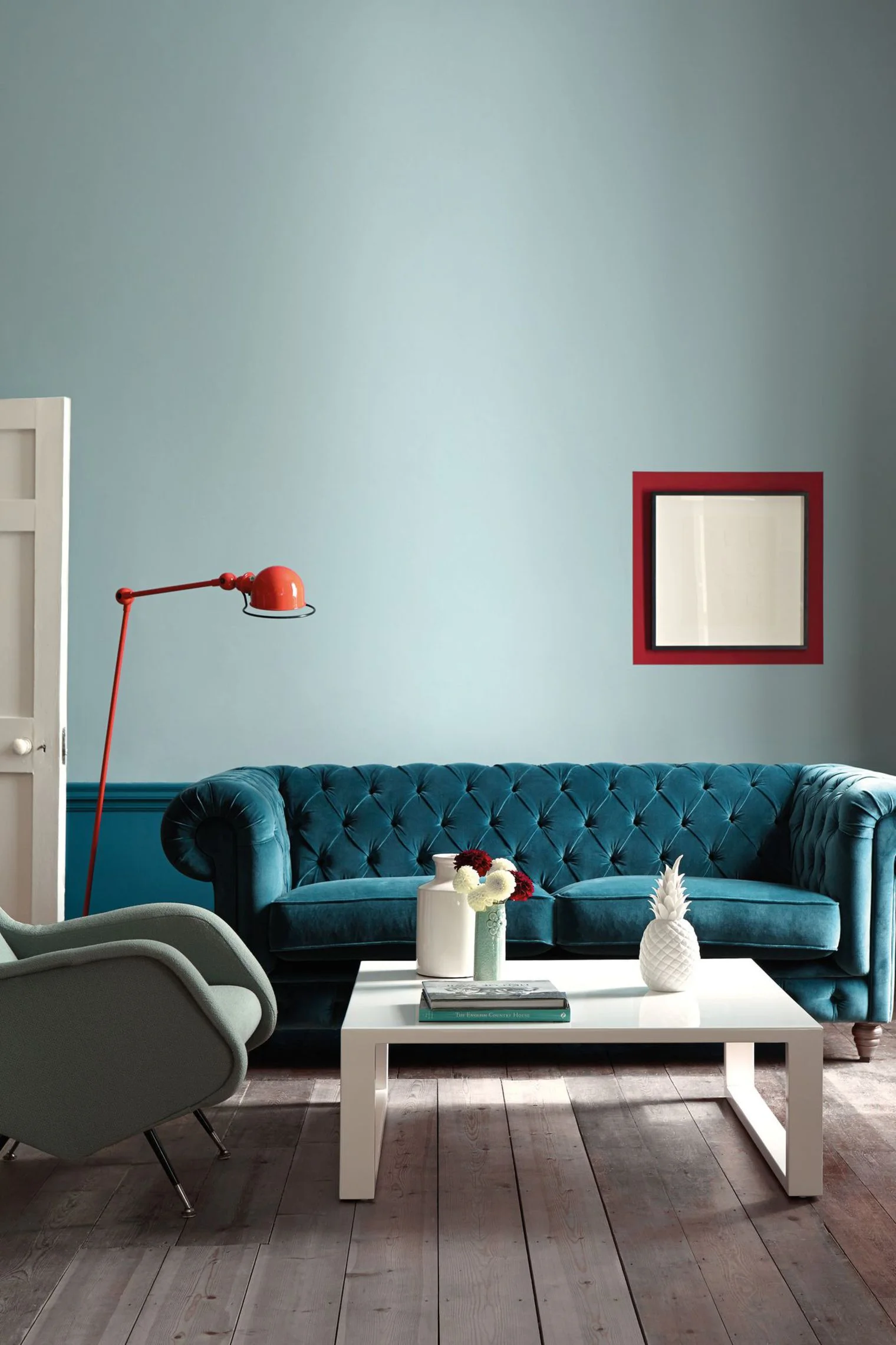 canape-velours-bleu-peintures-bleues-lampe-industrielle-rouge-table-basse-et-fauteuil_5789387.jpg
