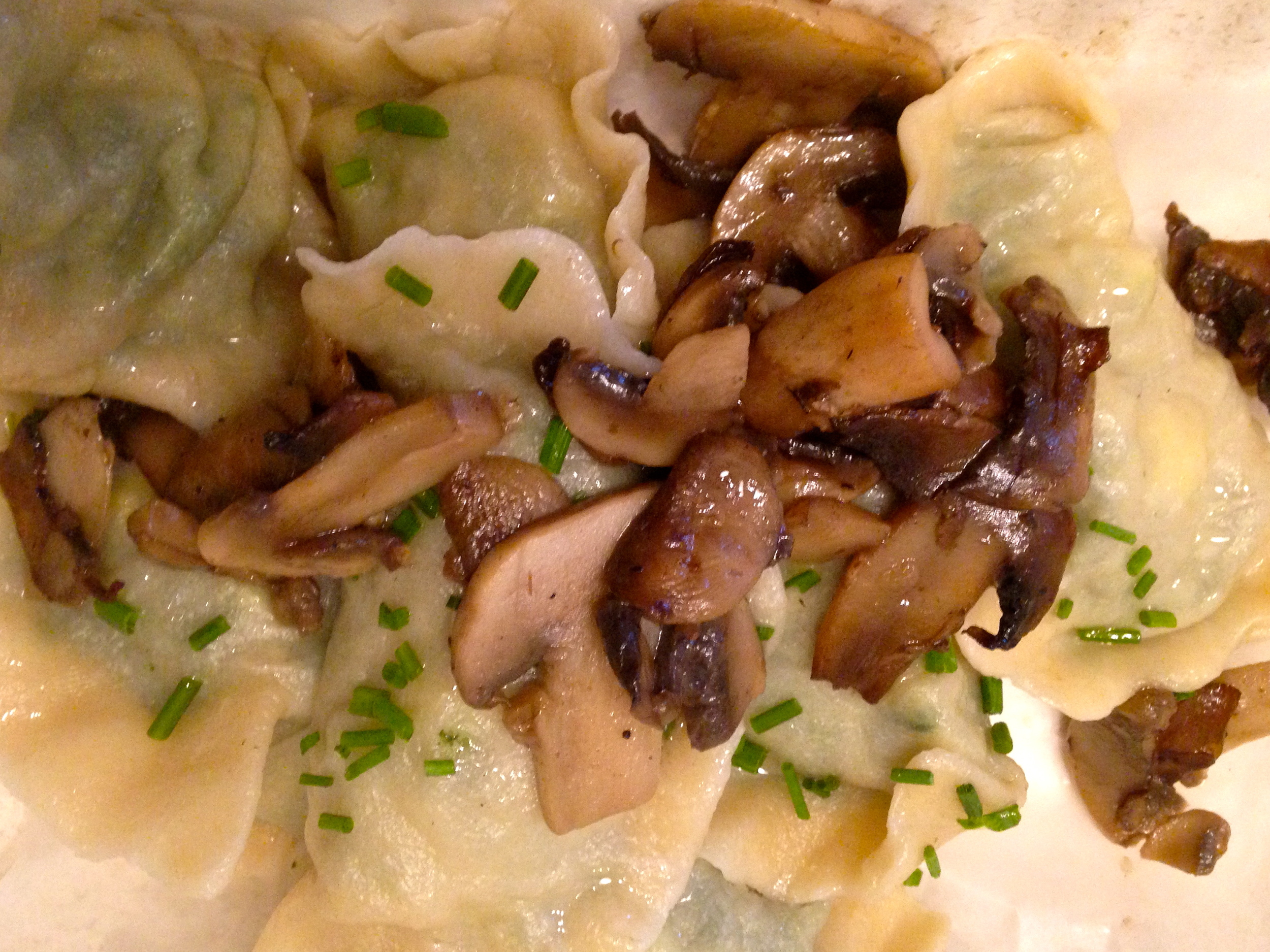 Boiled pierogies tossed in butter and chives, topped with mushrooms.