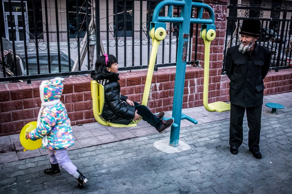 An older Uyghur man and young children.