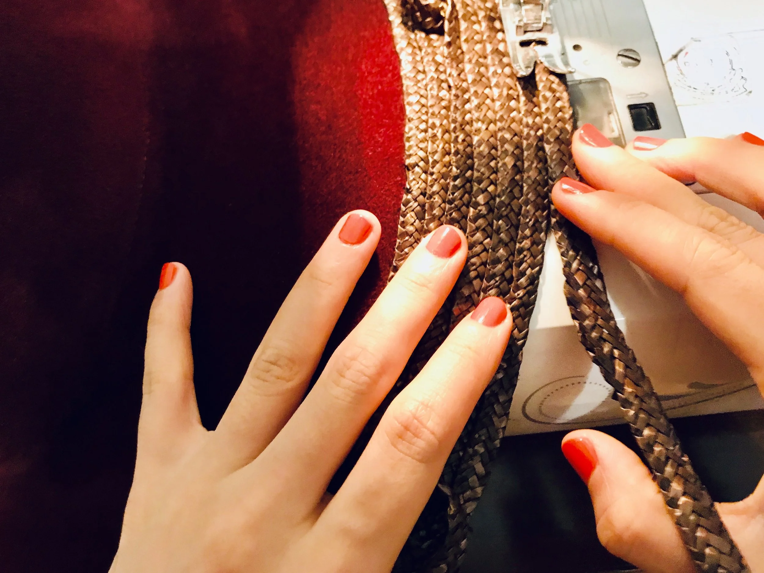 Snow-capped mountains under a cloudy sky with low clouds, brown rolling hills with sparse vegetation, and a modern building at the base of the hills.