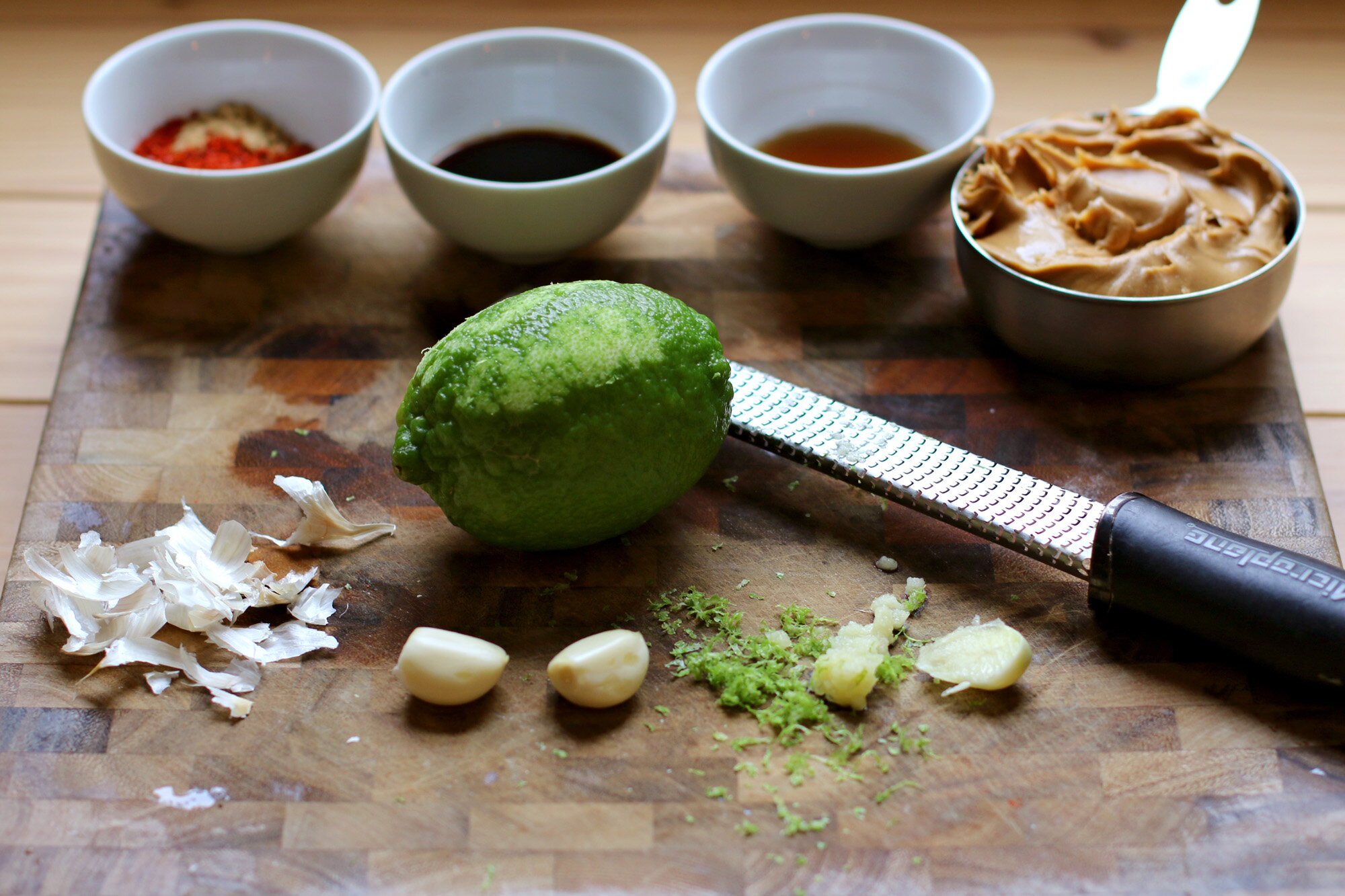  Using a Microplane, grate the lime zest and garlic. 