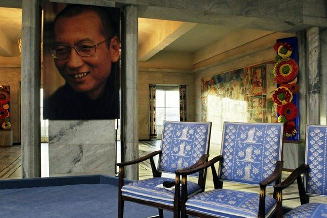  A portrait of imprisoned writer Liu Xiaobo hangs near the empty chair placed in his honour during the ceremony in Oslo, Norway in which he was awarded the Nobel Peace Prize in absentia on Dec. 10, 2010. Photo: AFP 