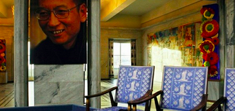   A portrait of imprisoned writer Liu Xiaobo hangs near the empty chair placed in his honour during the ceremony in Oslo, Norway in which he was awarded the Nobel Peace Prize in absentia on Dec. 10, 2010. Photo: AFP  