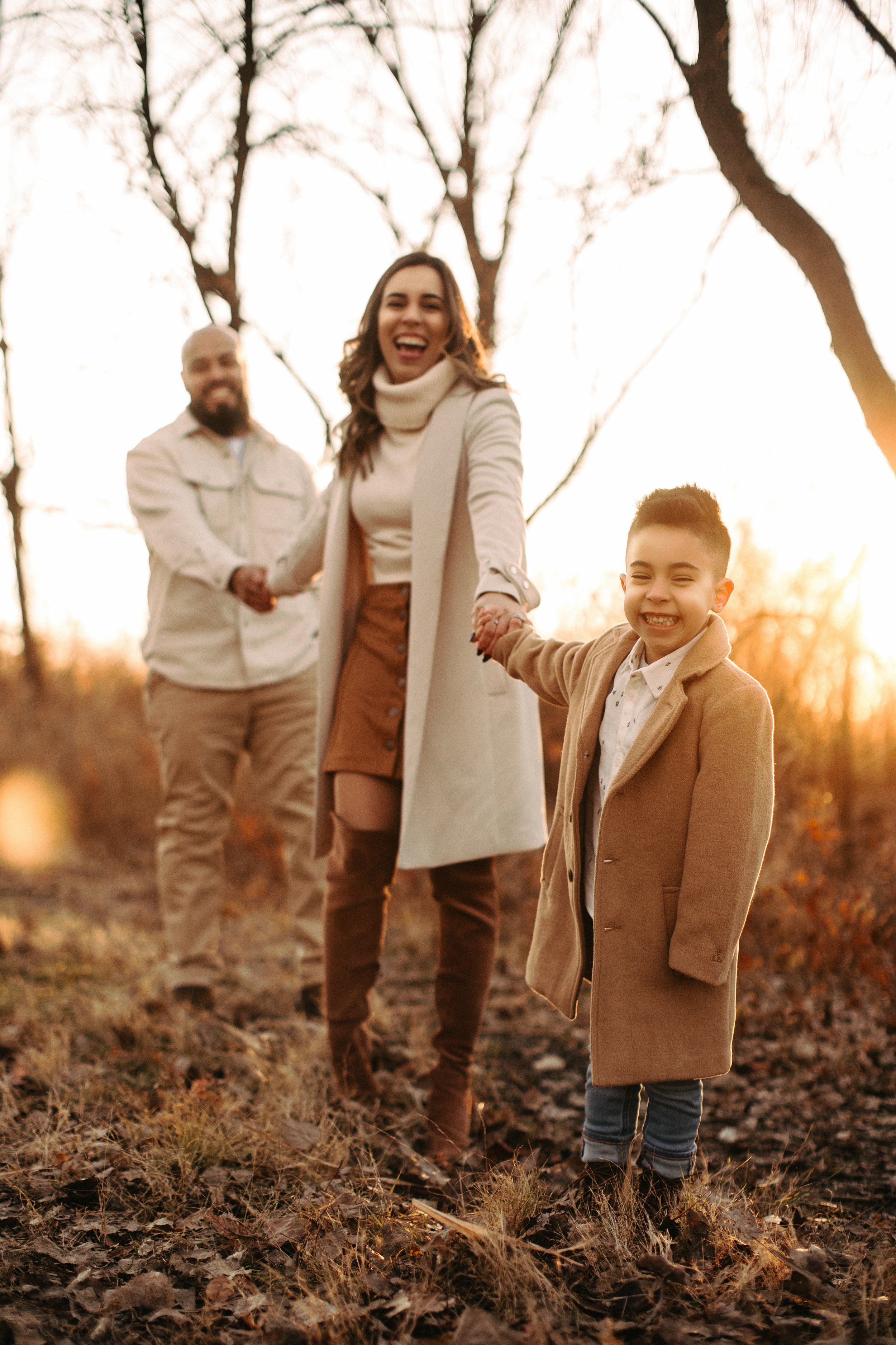 Family walking in autumn park, holding hands, wearing coats