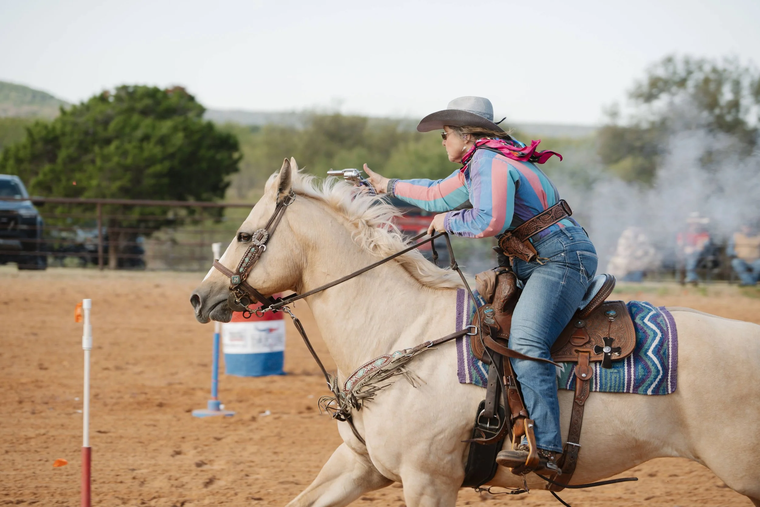 Mounted Shooting is a rider on horseback shooting pistols or shothuns at balloon targets while racing the block and the barrels in a pattern like this rider at Wildcatter Ranch and Resort.