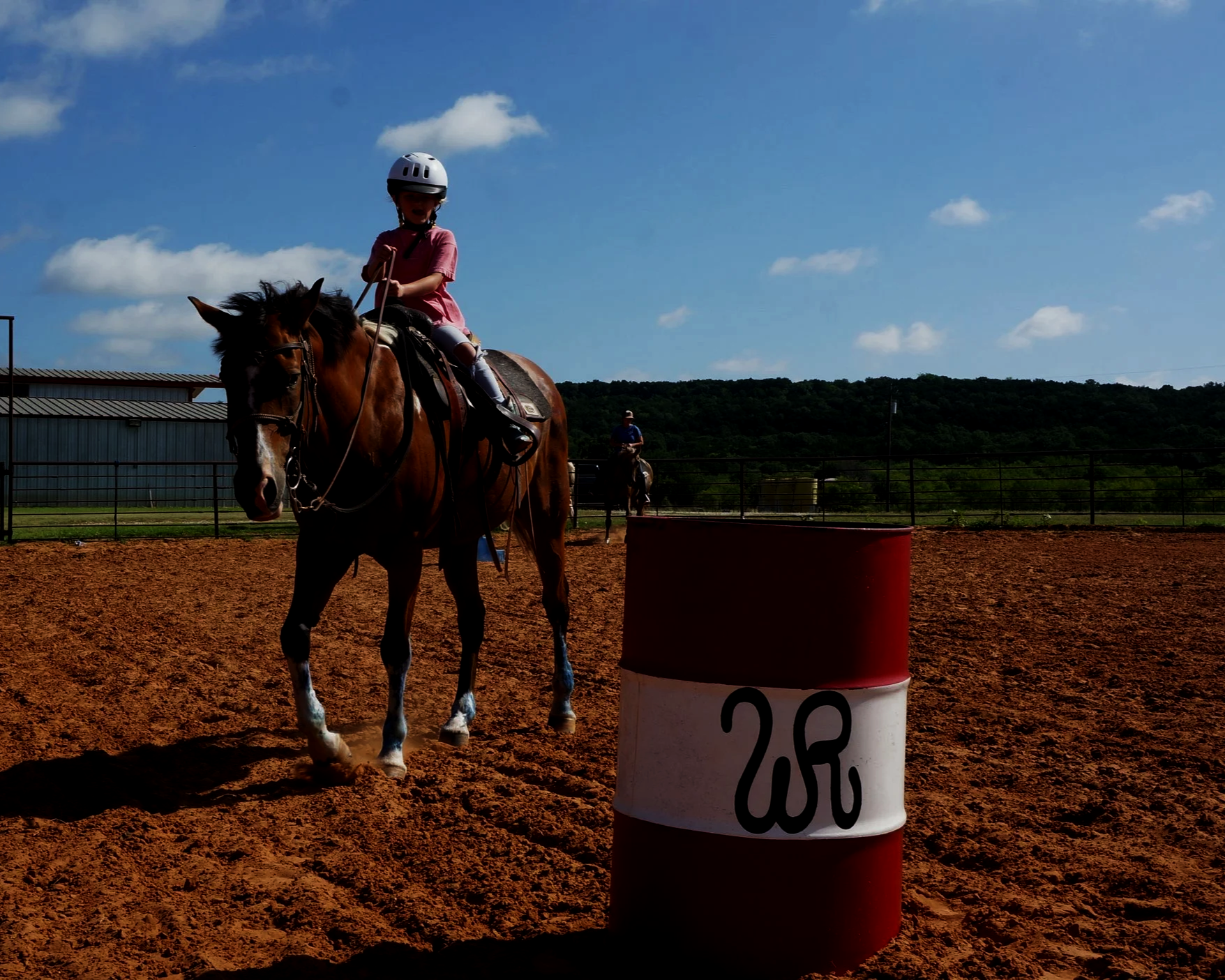 Kids horseback riding ranch in Texas with a young girl riding in the arena at Wildcatter.