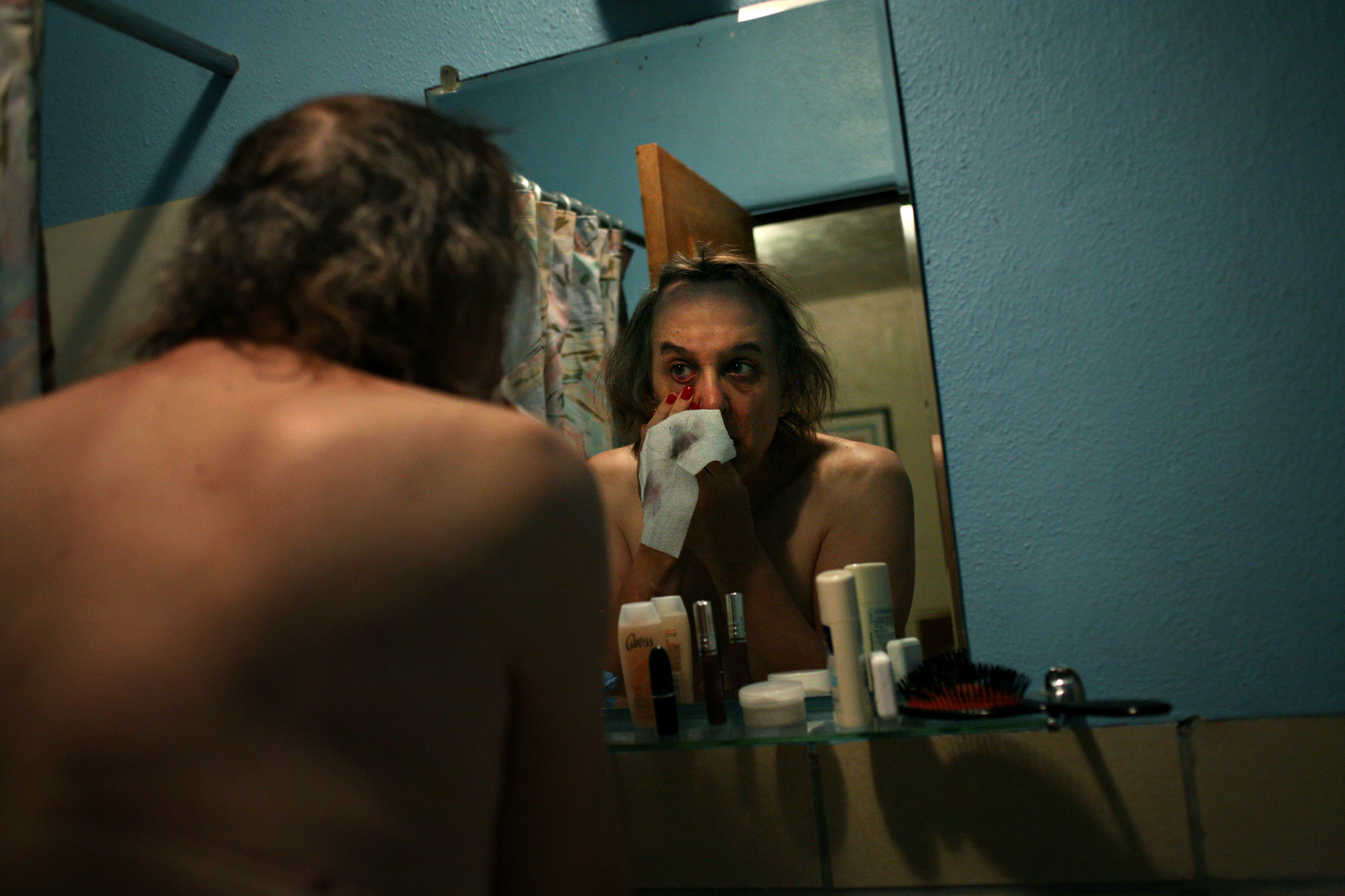  Elena washes the makeup from her eyes in a hotel bathroom in Trinidad, Colo., on the night before her genital reassignment surgery. 