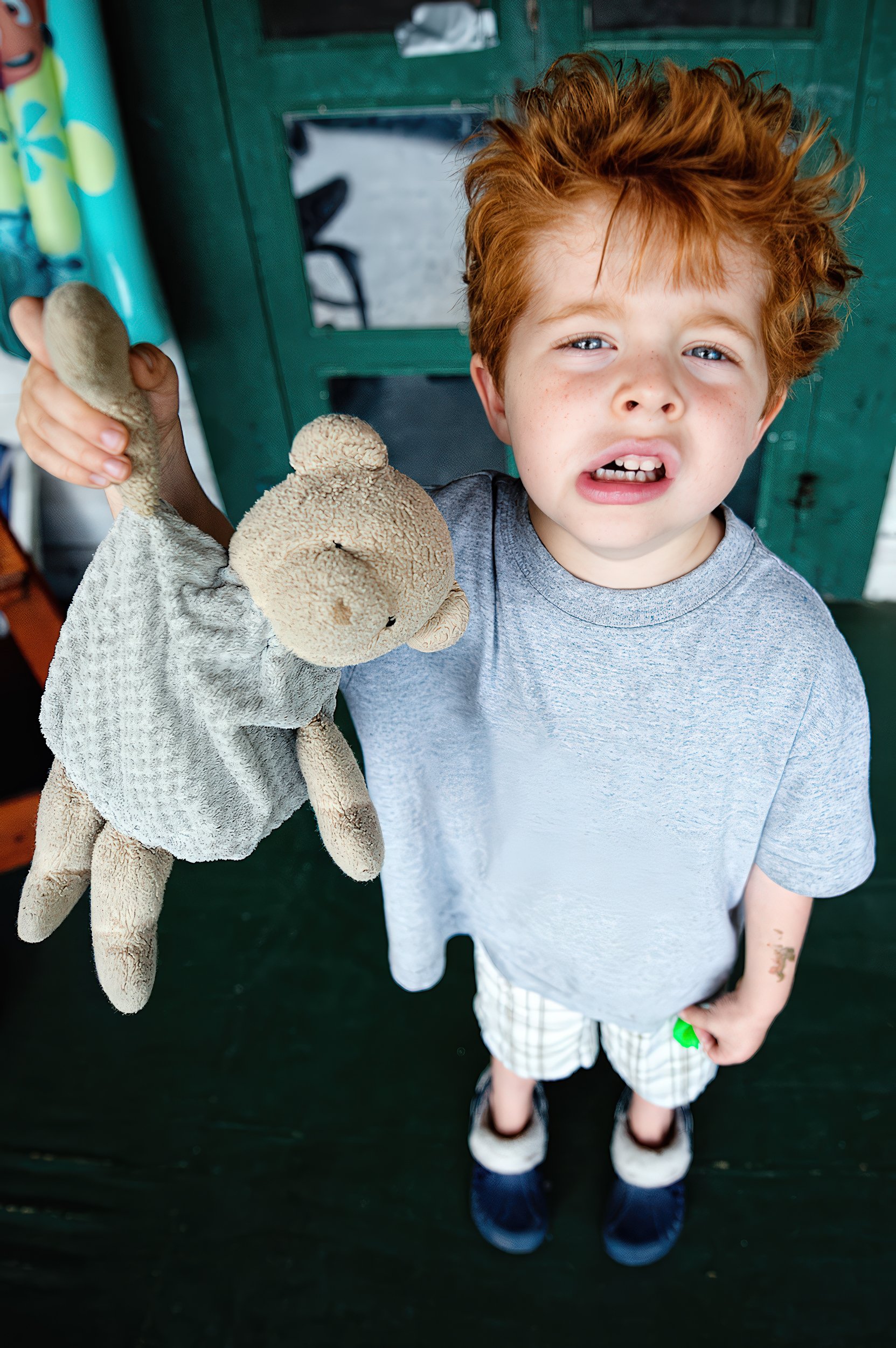 child-holding-teddy-bear-red-hair-emotional-candid.jpg