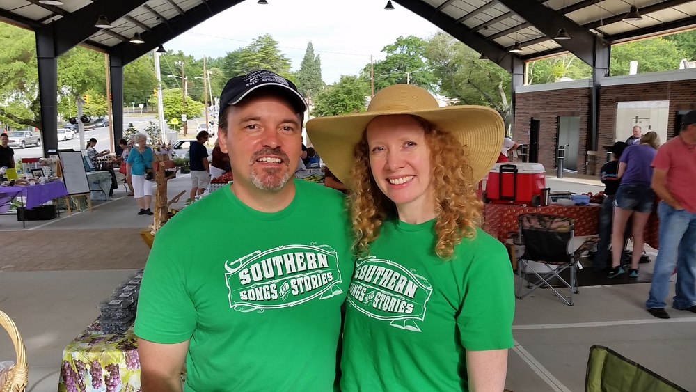 Joe and Amy Kendrick wearing their Southern Songs and Stories t-shirts at the Shelby, NC farmers market