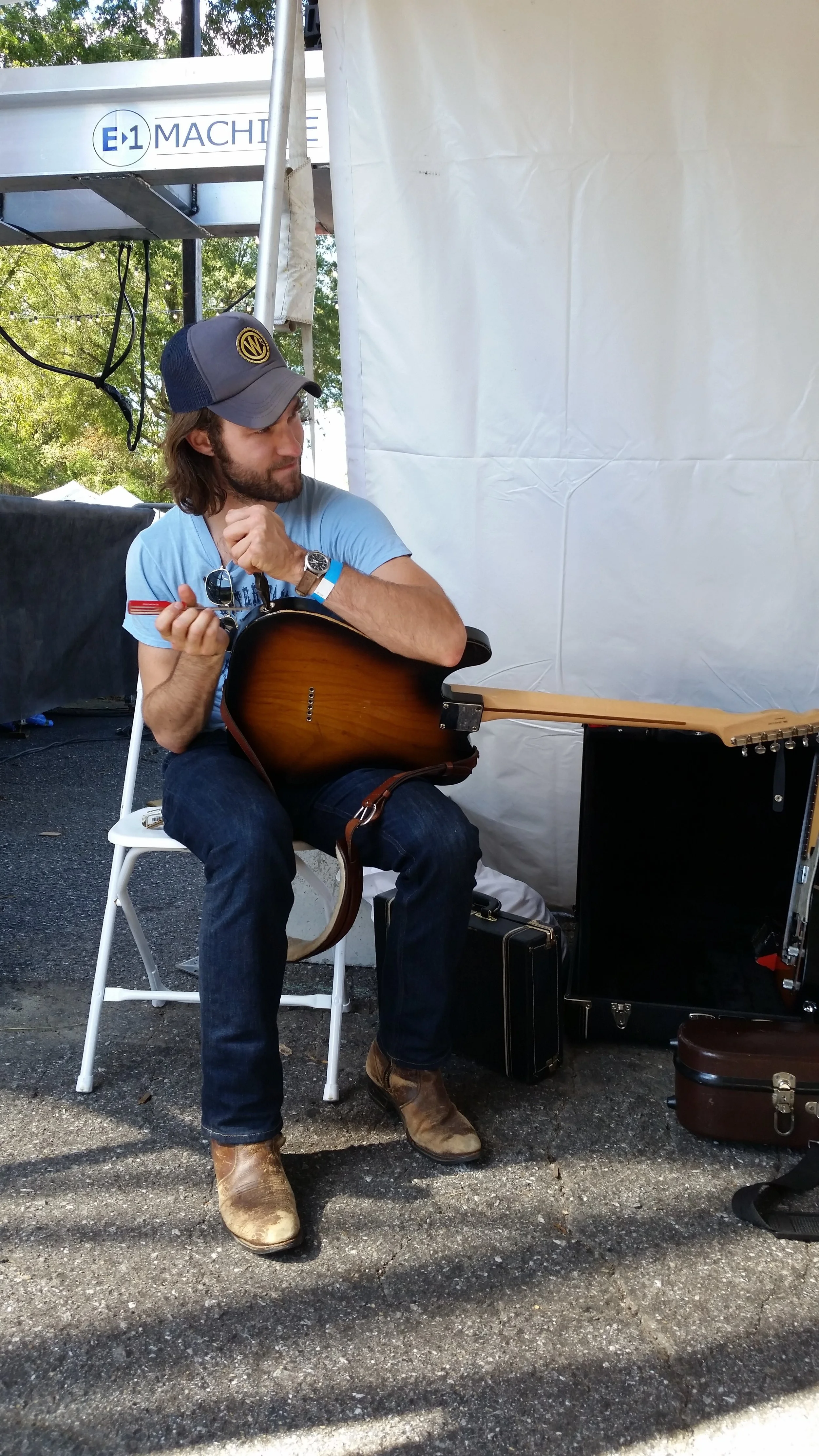 Josh Vana of Nora Jane Struthers & the Party Line works on his guitar backstage