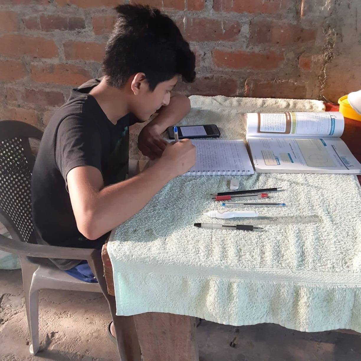 Before computers were provided, a student here is using his cellphone to work on his studies