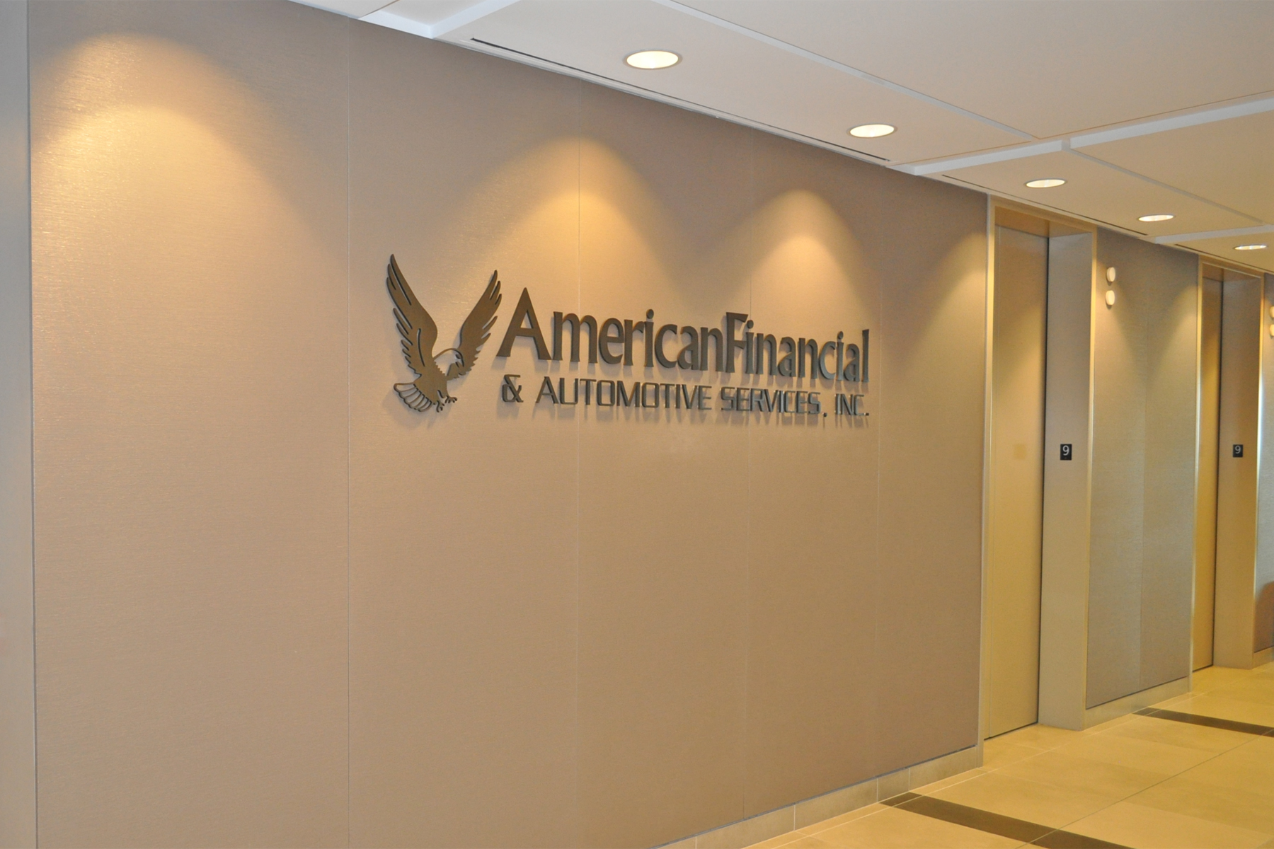 Branding in the Elevator Lobby - Dark Bronze Anodized Aluminum Letters against a light colored fabric wall to create a high contrast, appealing look
