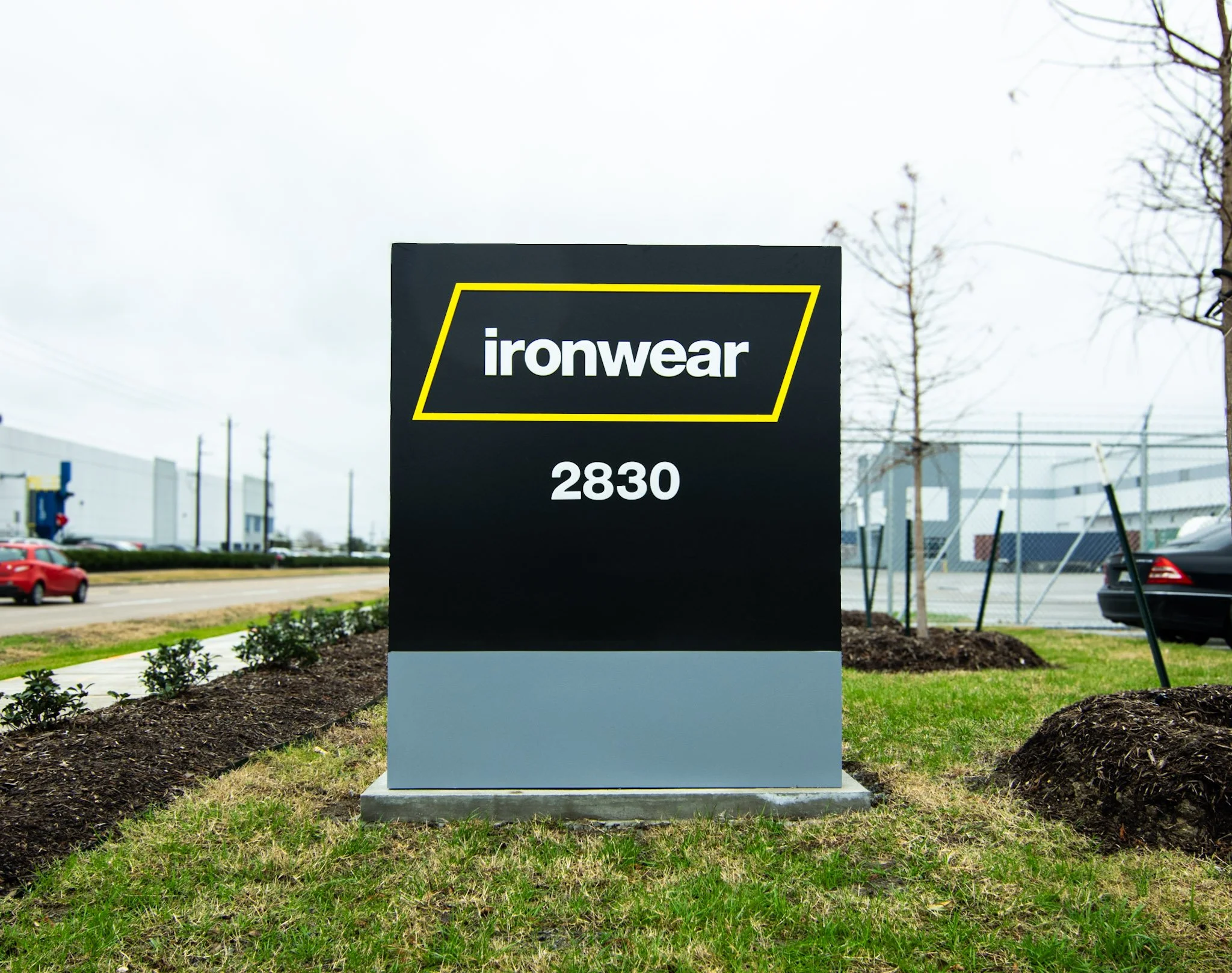 Modern monument sign displaying the Ironwear logo and address at the corporate facility entrance for outdoor business identification.