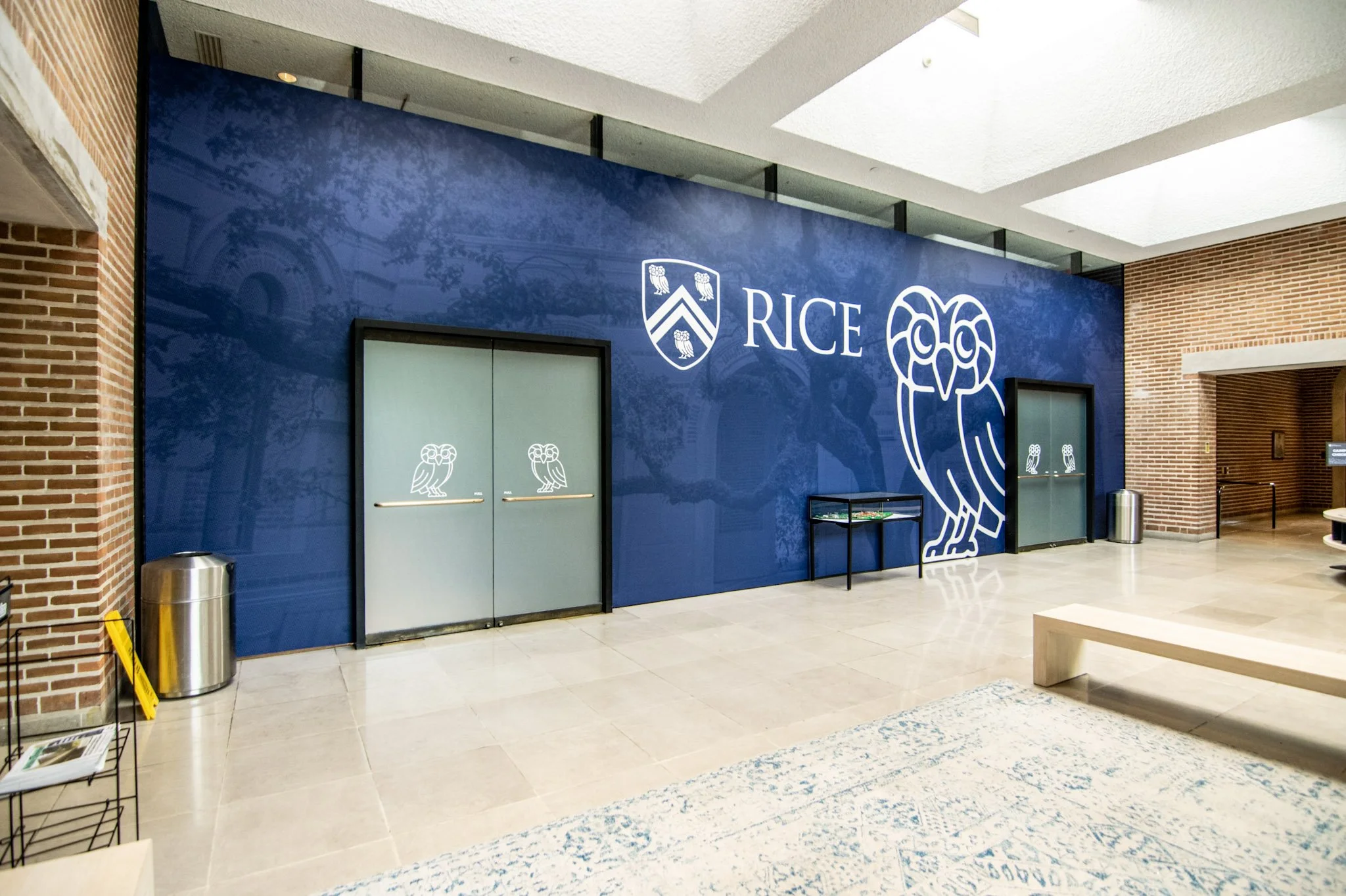Wide view of a custom Rice University lobby wall wrap featuring the university logo and owl graphic, installed by Saifee Signs in a campus building.